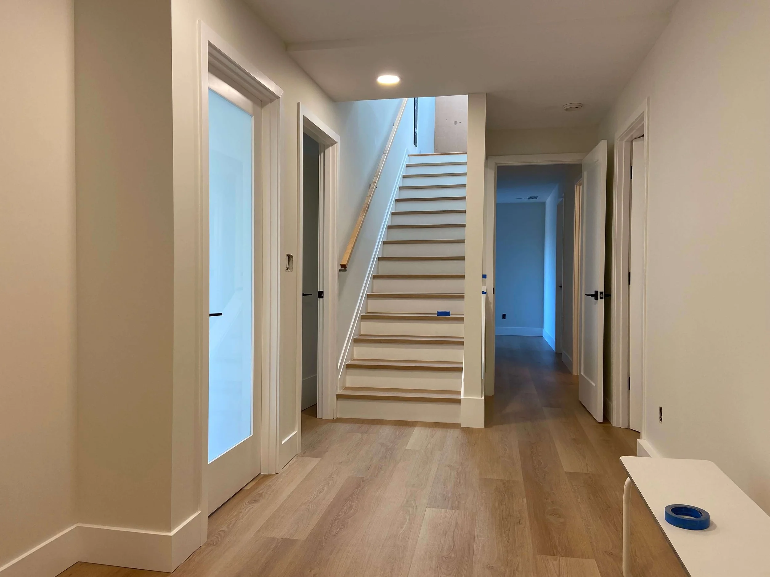 Completed Mercer Island basement hallway and stairwell with Level 4 drywall, PVA primer, and interior painting.