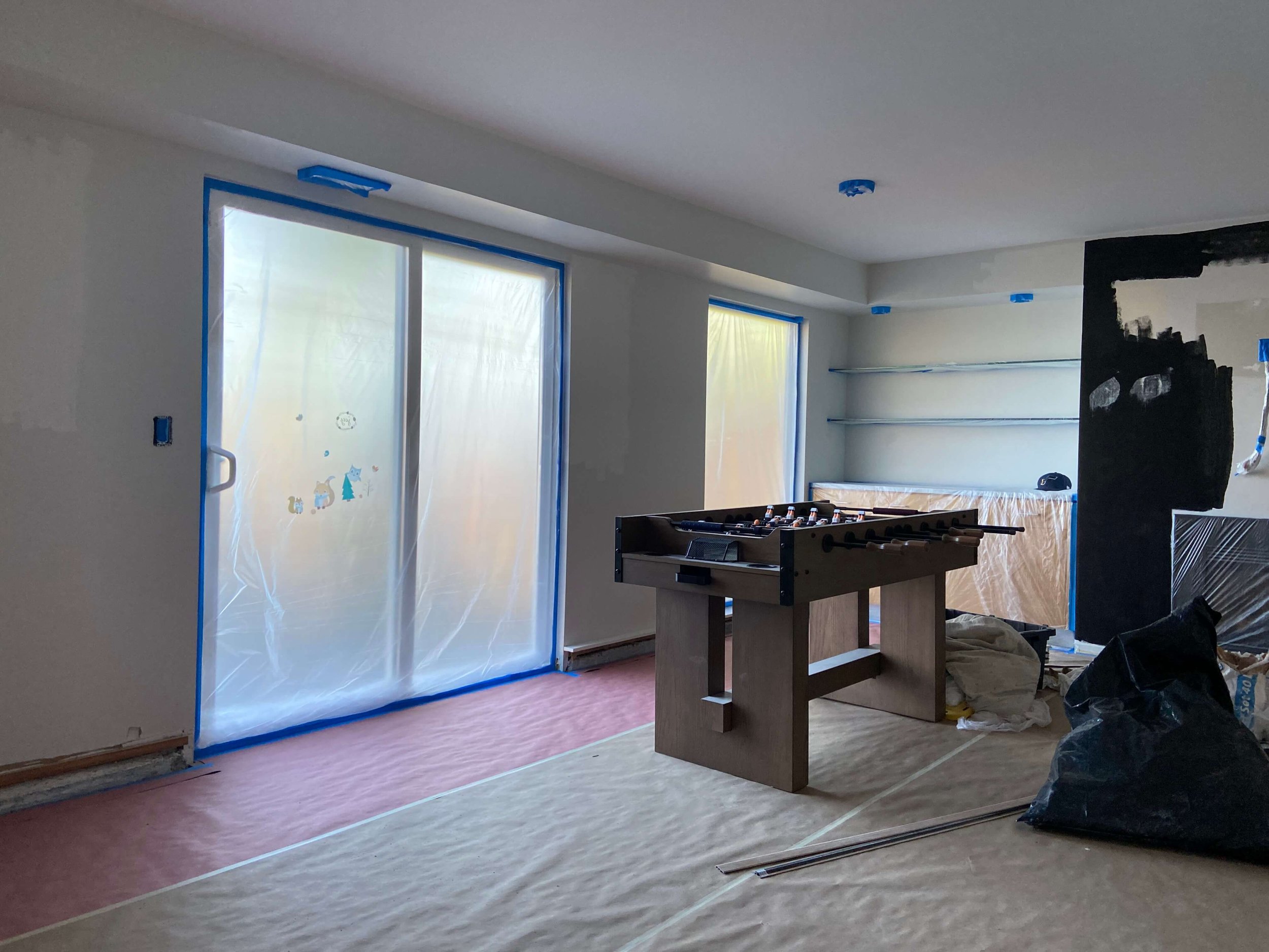 Interior painting underway in a Mercer Island basement with masked windows and protected floors.