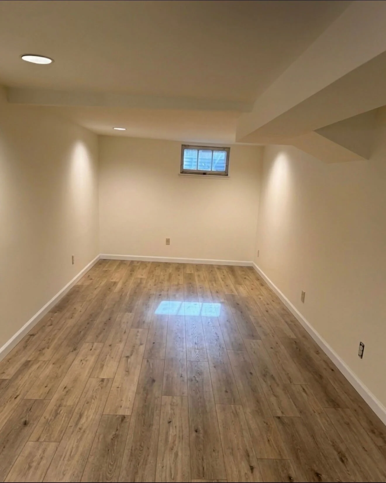 Finished basement in Queen Anne after drywall repair, skim coating, and interior painting with smooth modern walls and a Level 5 appearance.
