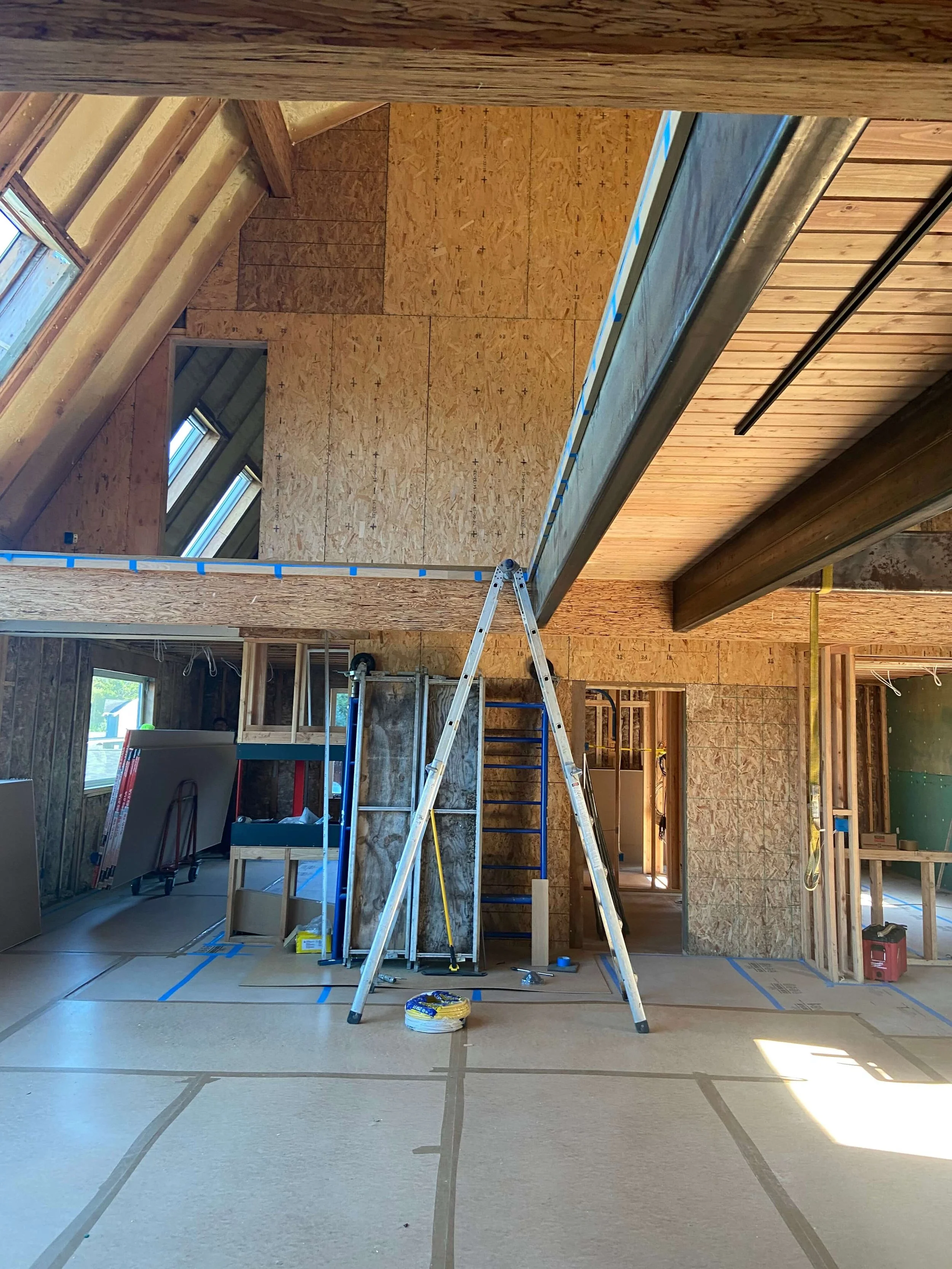 Before Level 5 skim coat drywall refinishing during a whole-home remodel in Redmond, WA, showing existing drywall before smooth wall preparation, recessed baseboard installation, and architectural interior finishing.