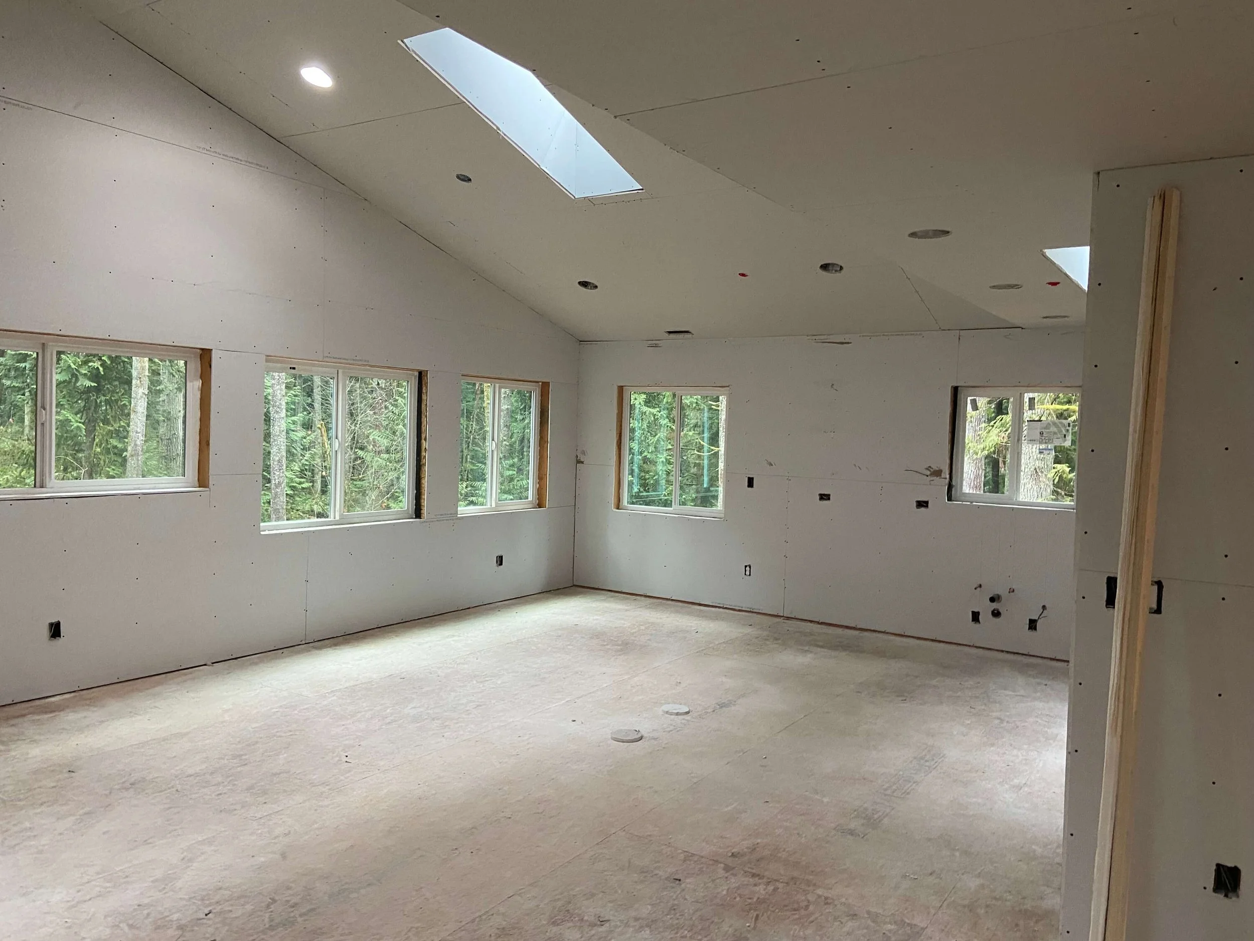 New drywall installed throughout the walls and vaulted ceiling of an ADU in Issaquah, Washington.