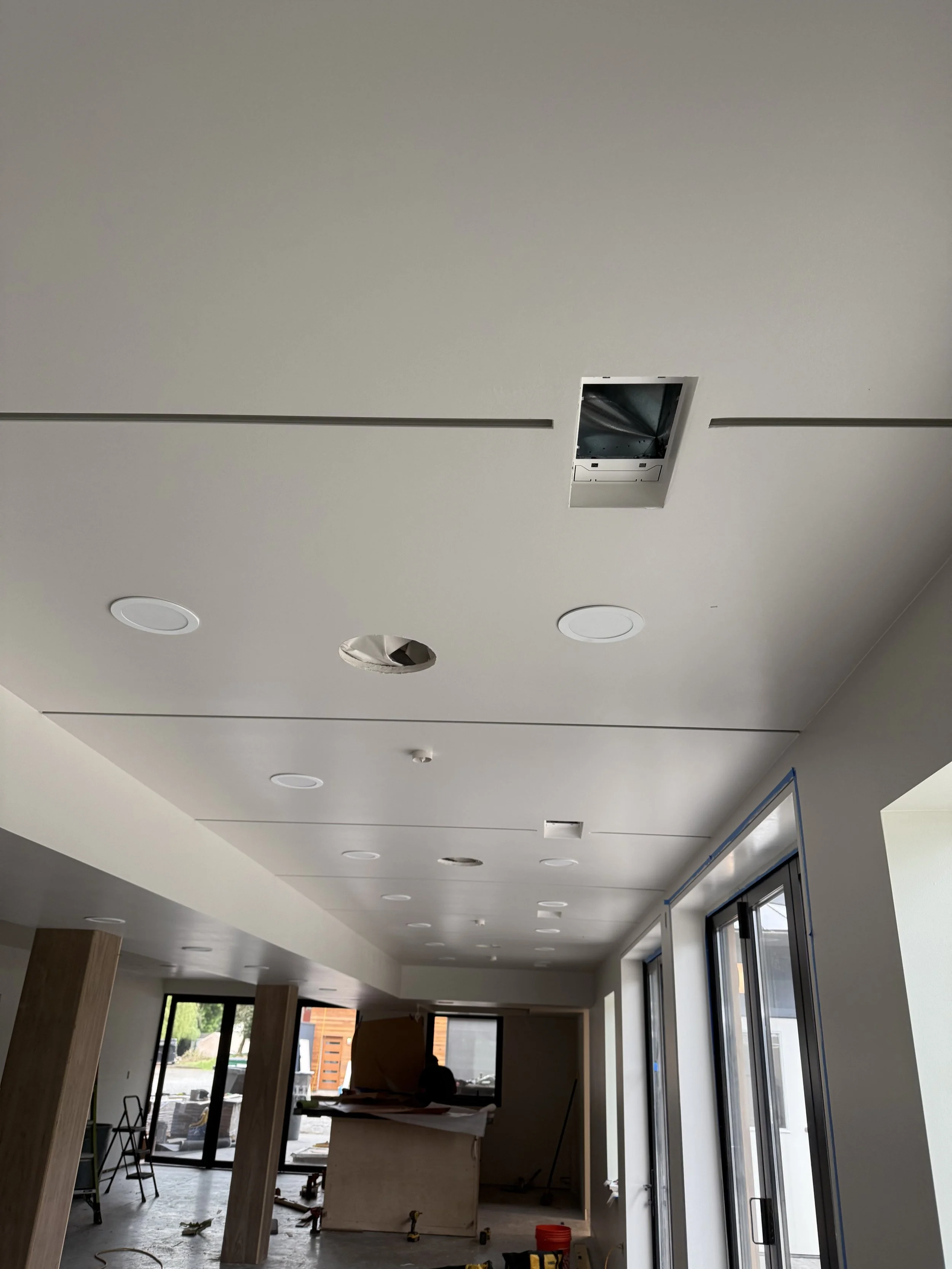 Smooth Level 5 drywall ceiling in Redmond with recessed black reglet lines, flush vents and integrated lighting.