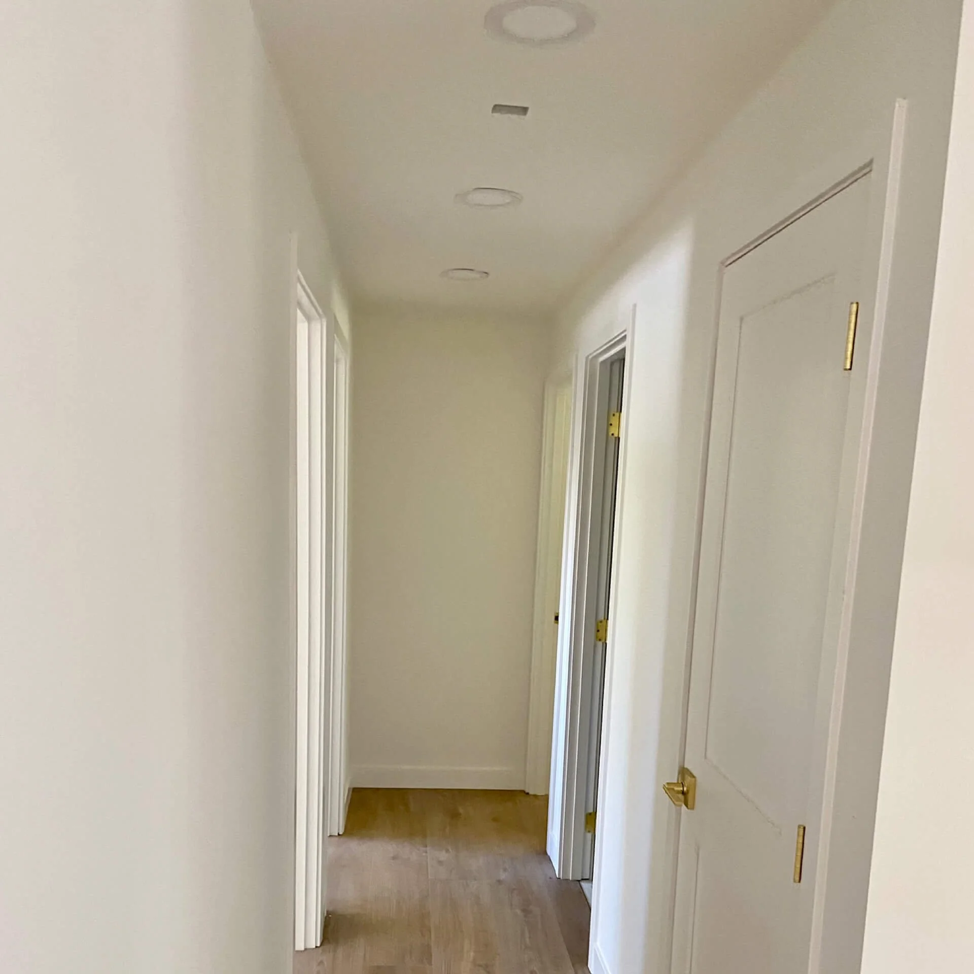 After popcorn ceiling removal in a Redmond WA hallway with skim-coated smooth ceiling and walls, finished with professional interior painting.