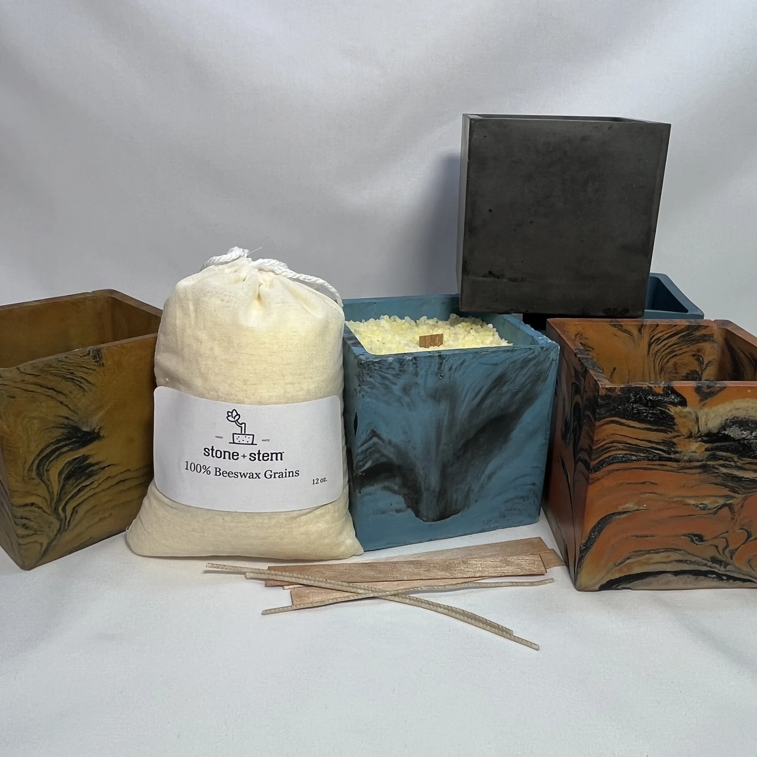 various colored concrete cube planters with bag of beeswax grains, wooden wicks and cotton wicks