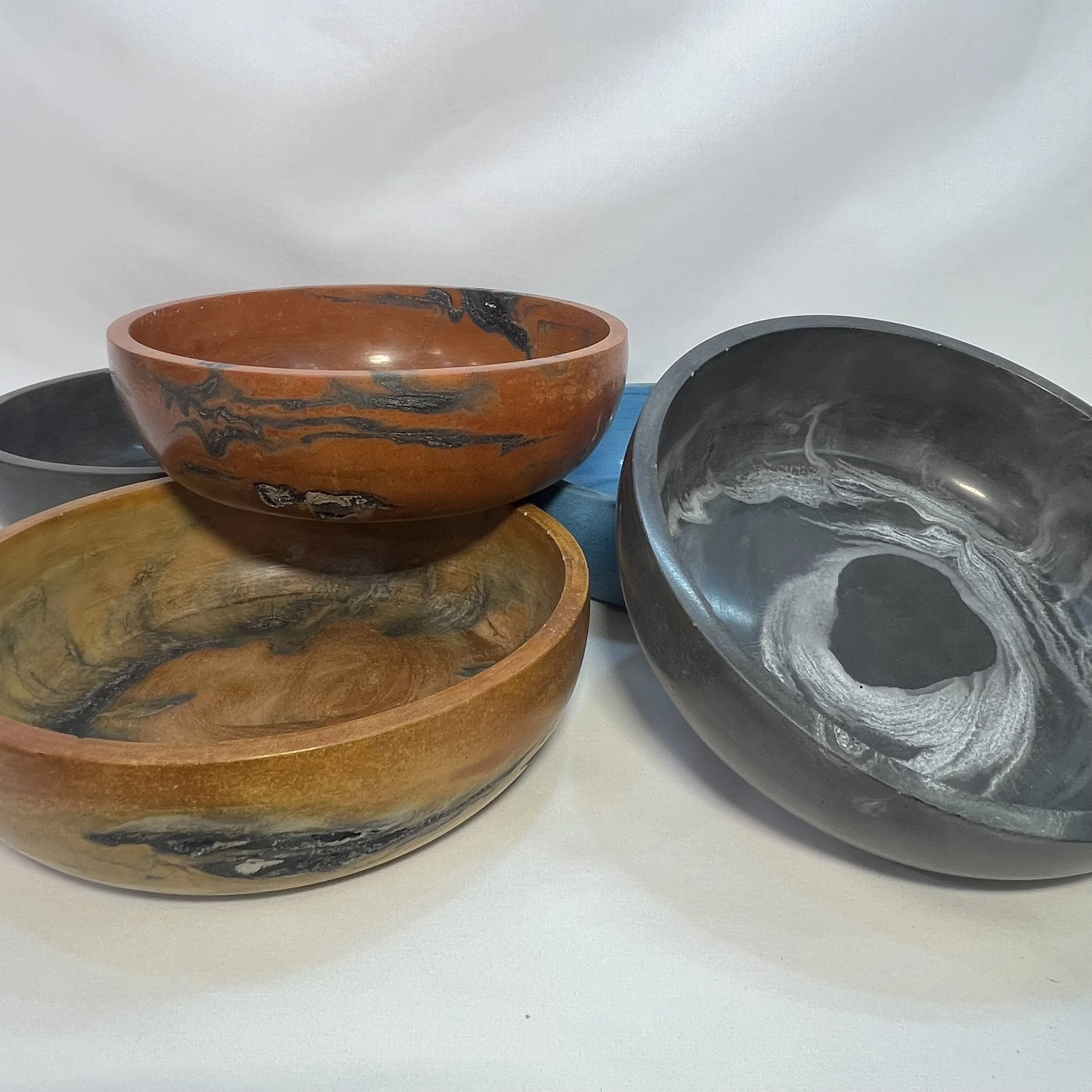 five concrete bowls in various colors