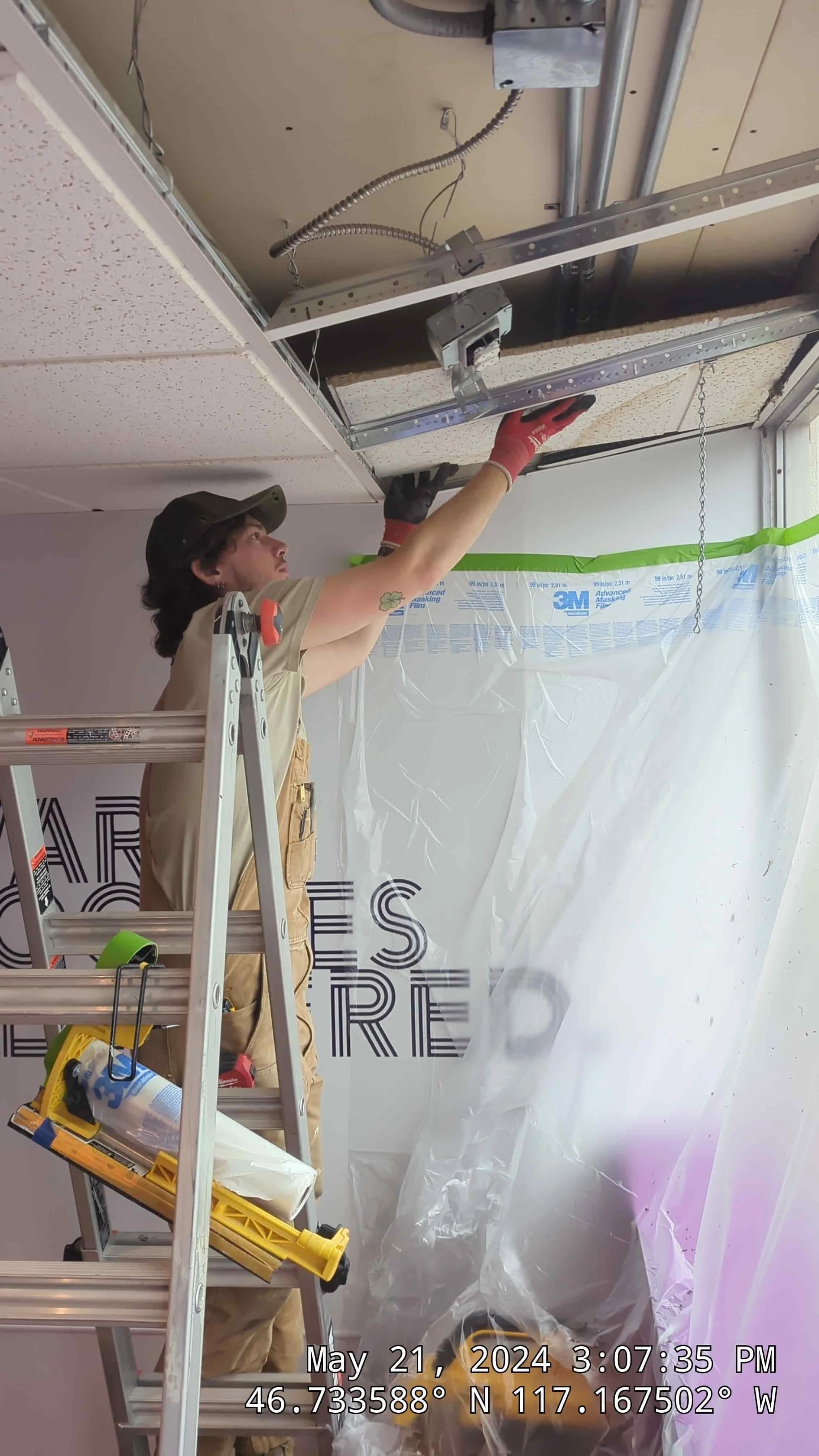 man replacing ceiling tiles