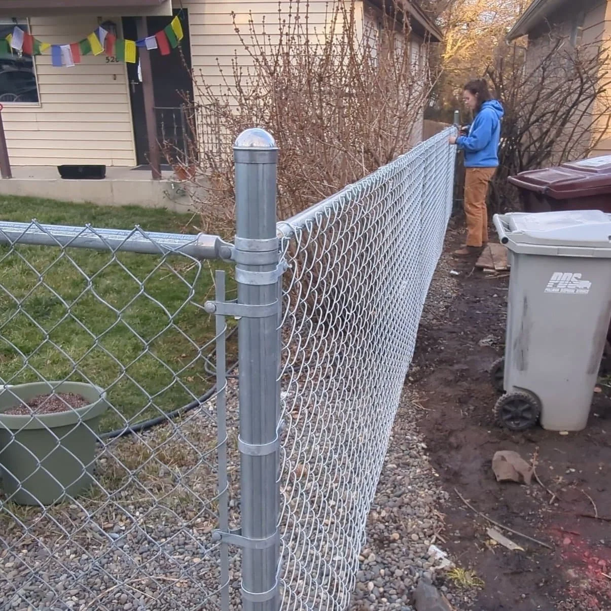 woman installing chain link fencing