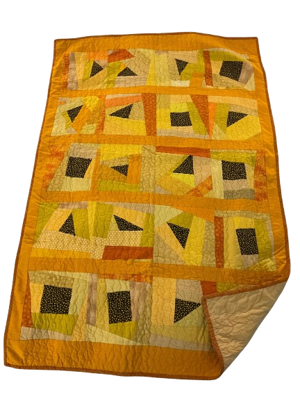 Handmade quilt with yellow and orange geometric patchwork pattern featuring black triangles and squares.