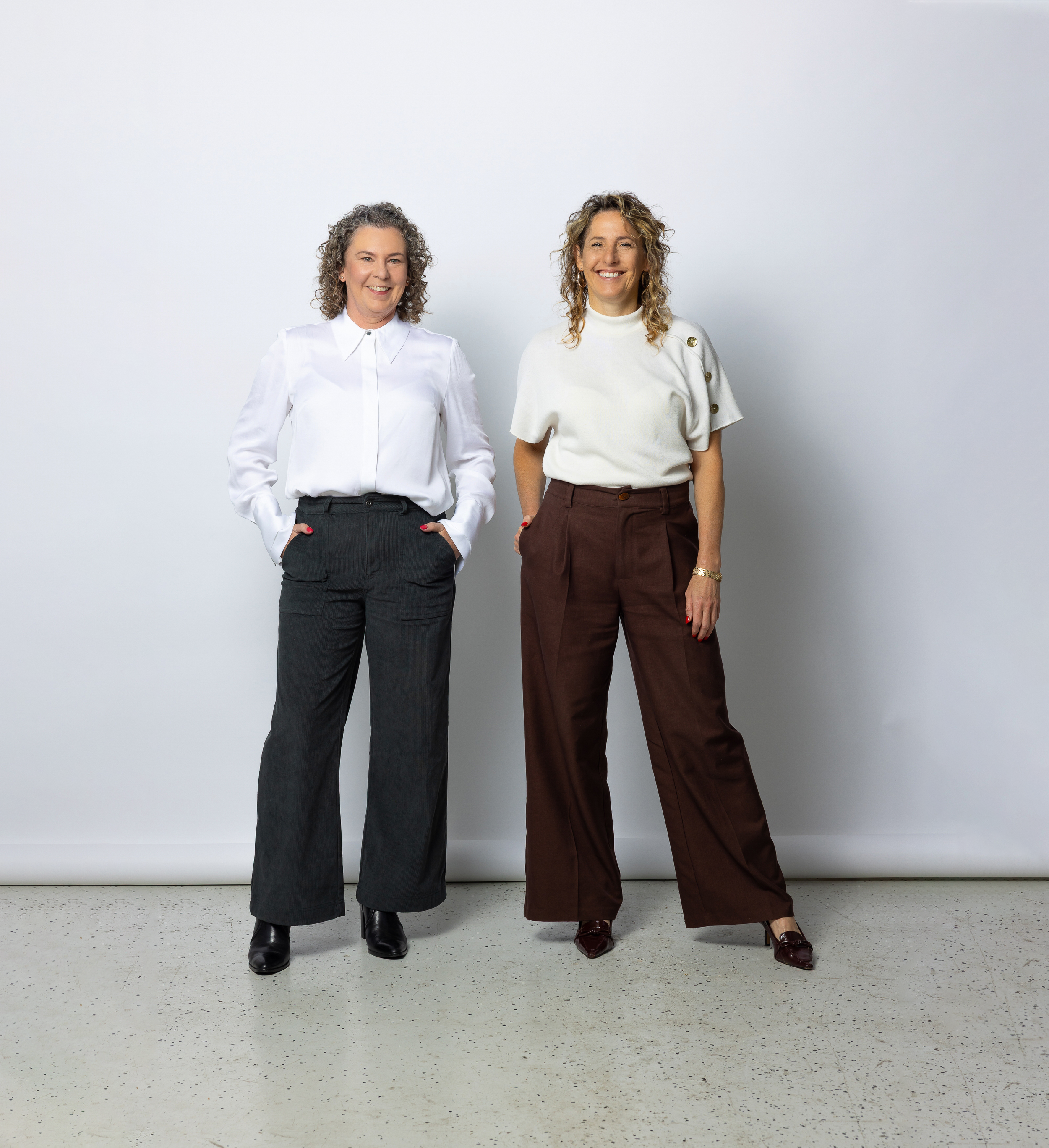 Sarah and Evelin standing smiling next to each other in a light open studio space.