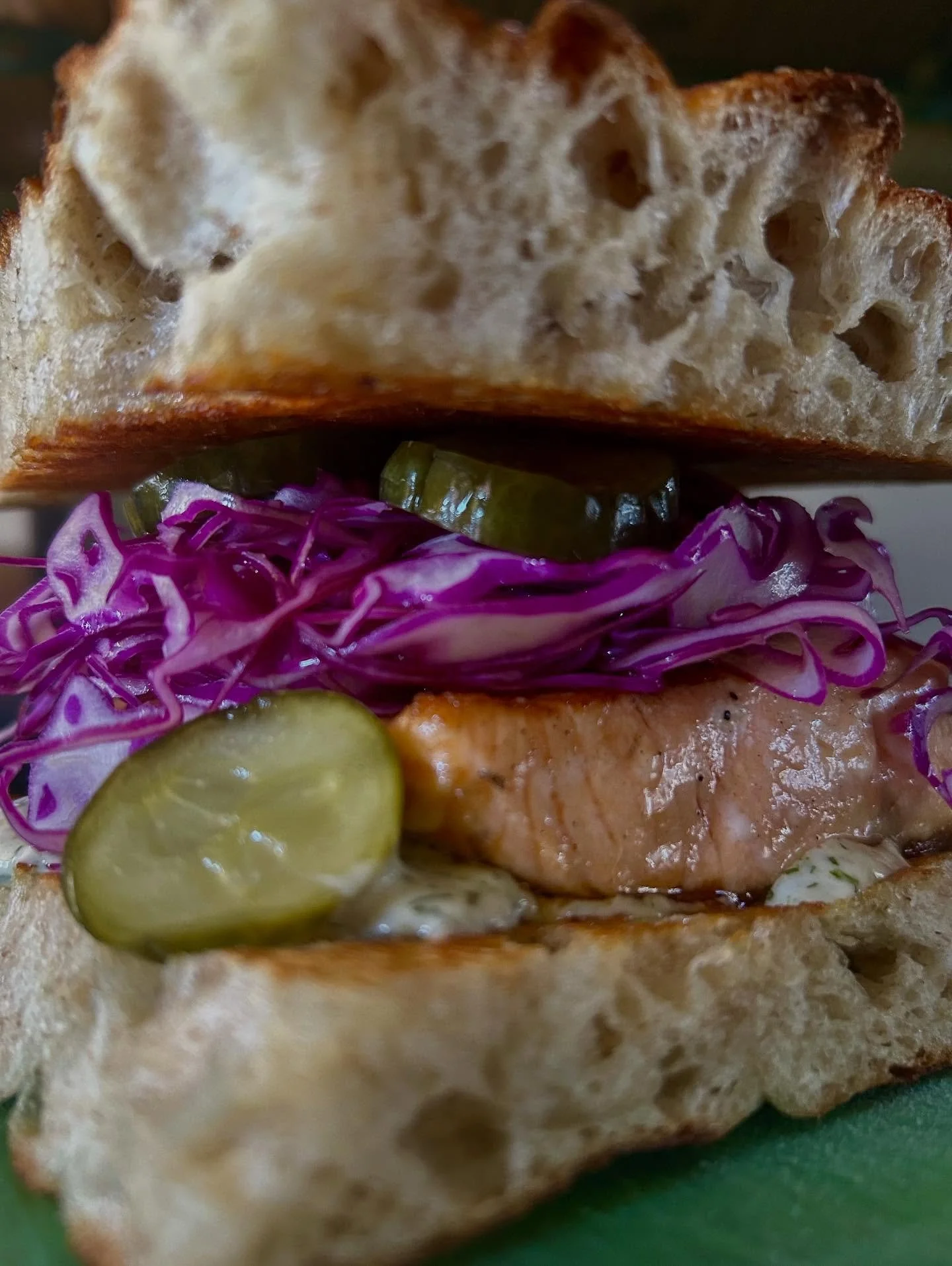 Wild Coho salmon w/ lemon dill mayo, shredded purple cabbage, and sweet and sour cucumber pickles on sourdough puffy stuff. Catch it before it snaps the line!