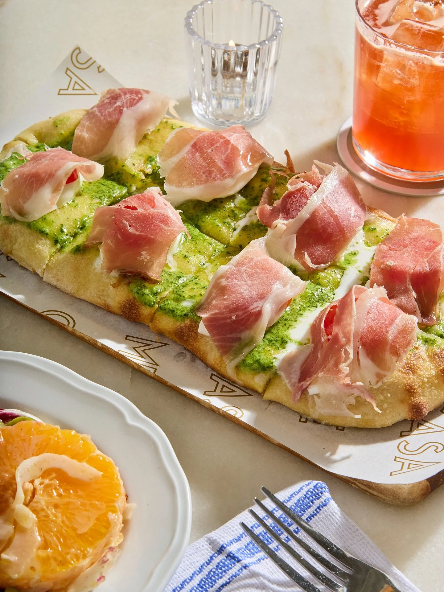 PINSA BUFALOTTA, prosciutto di parma, mozzarella di bufala, cherry tomato and arugula pesto.