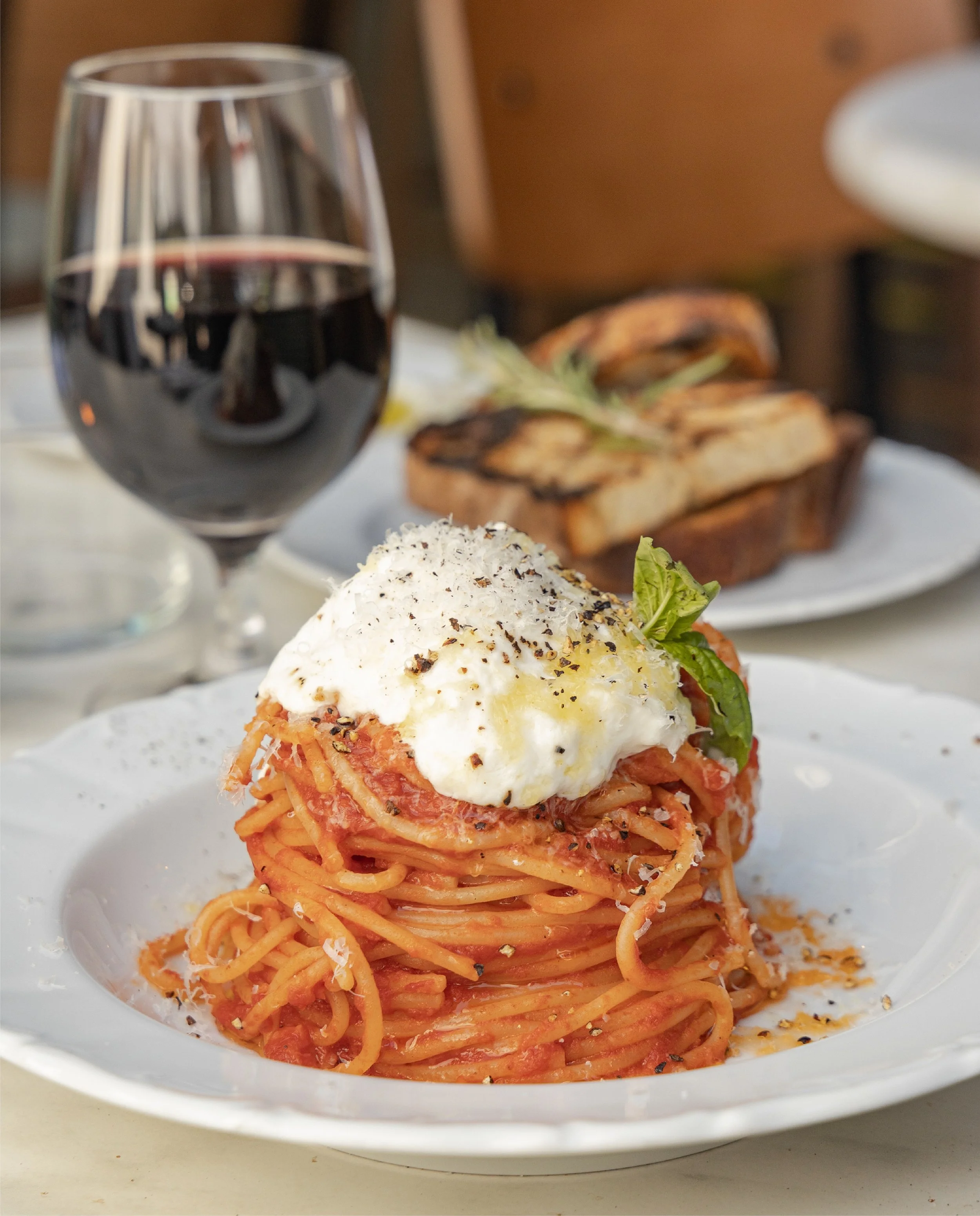 A match made in heaven, spaghetti and vino rosso. SPAGHETTI POMODORO, tomato sauce, parmigiano, and stracciatella 🍷