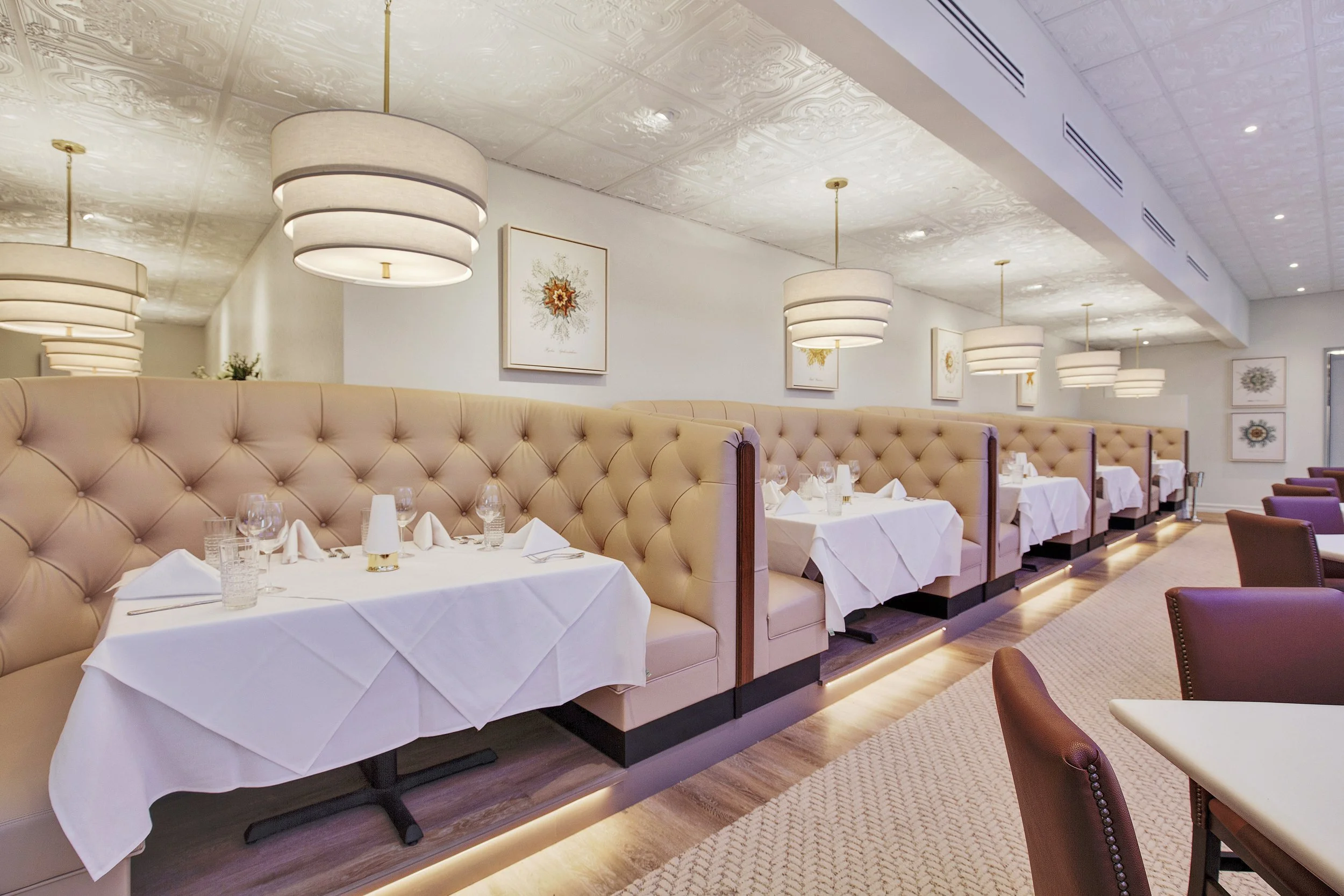 Ambrosia Dining Room in Watersound White tablecloth dining room and upholstered booths at Ambrosia in Watersound Town Center