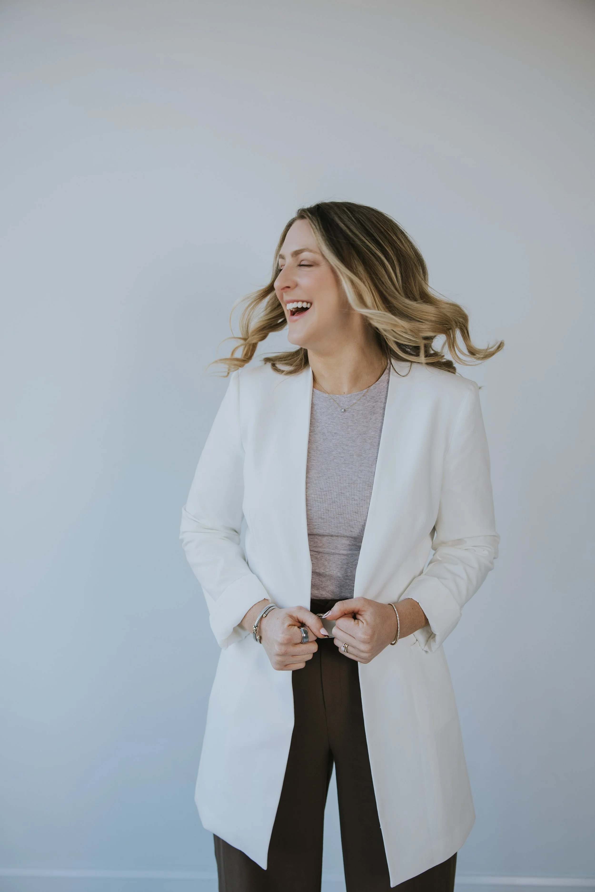 Kylie Lambert laughing, wearing a white blazer