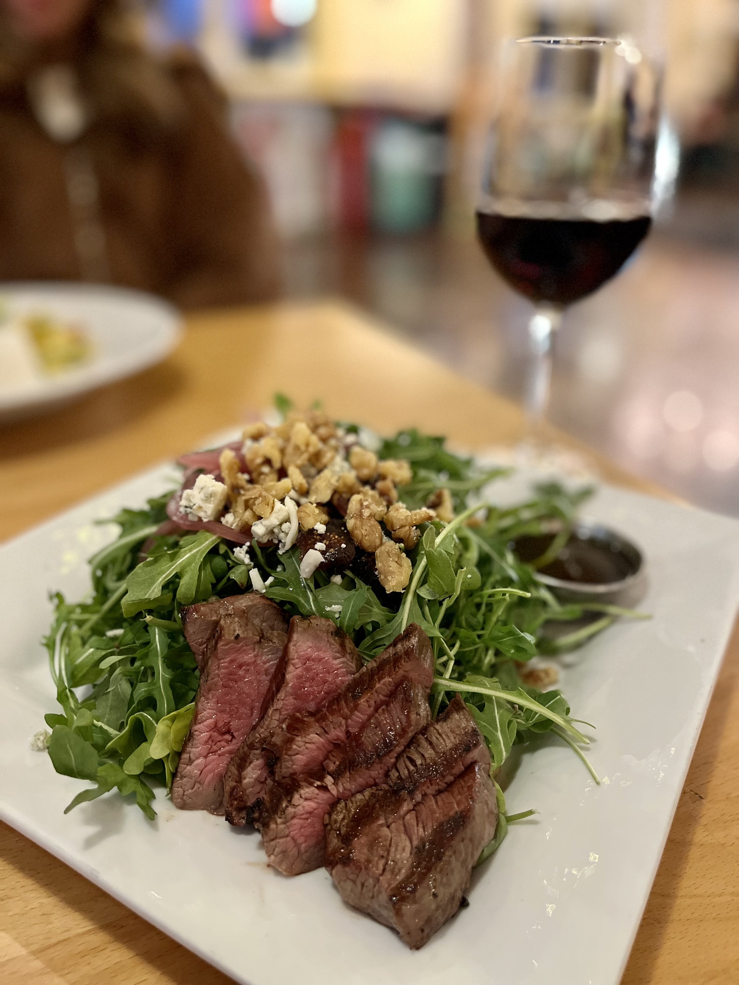 steak salad and glass of red wine