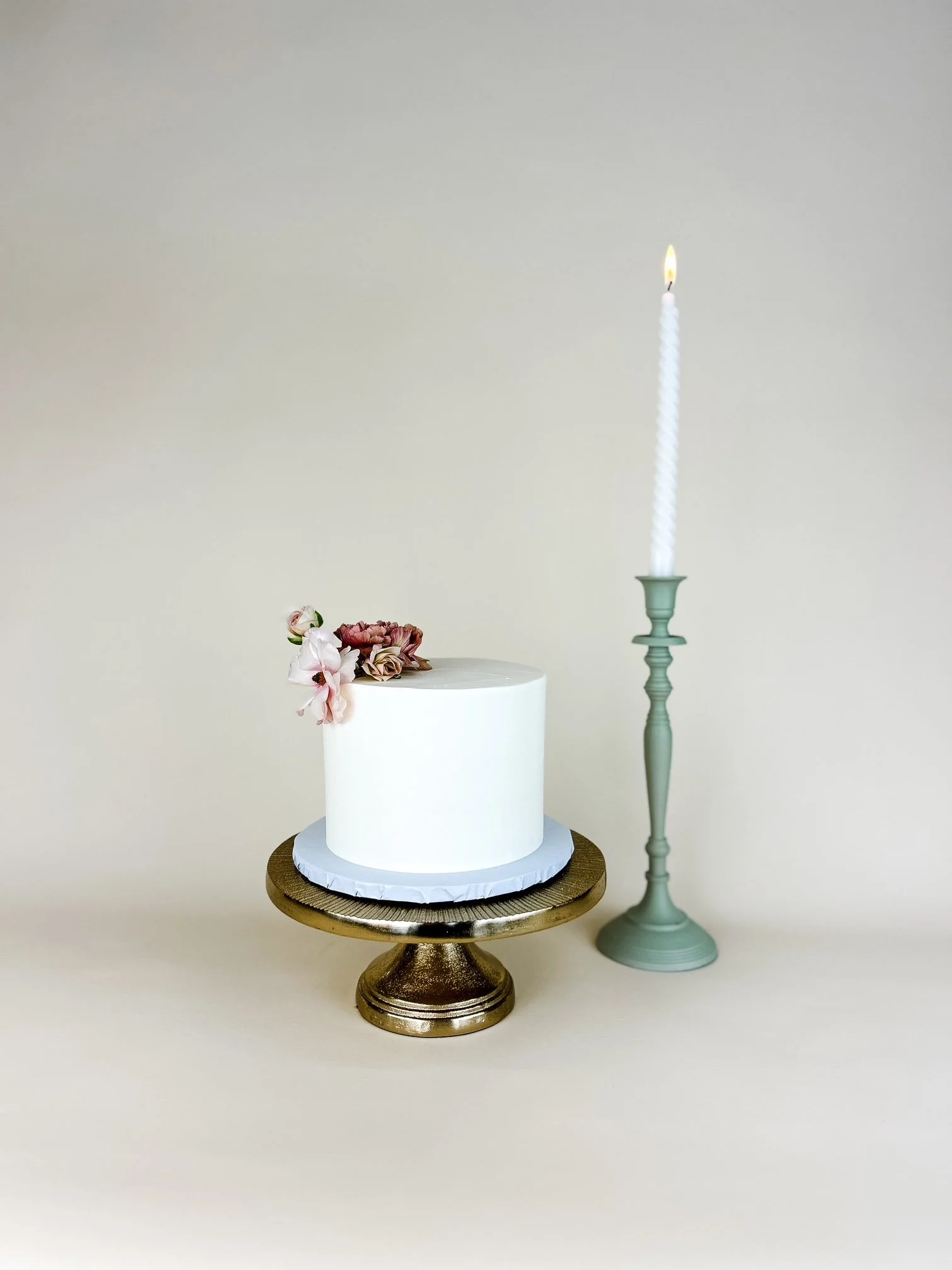 smooth frosted wedding cake with candle behind it