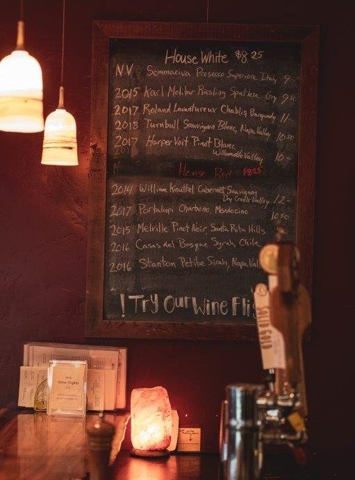 Wines by the glass menu on chalkboard