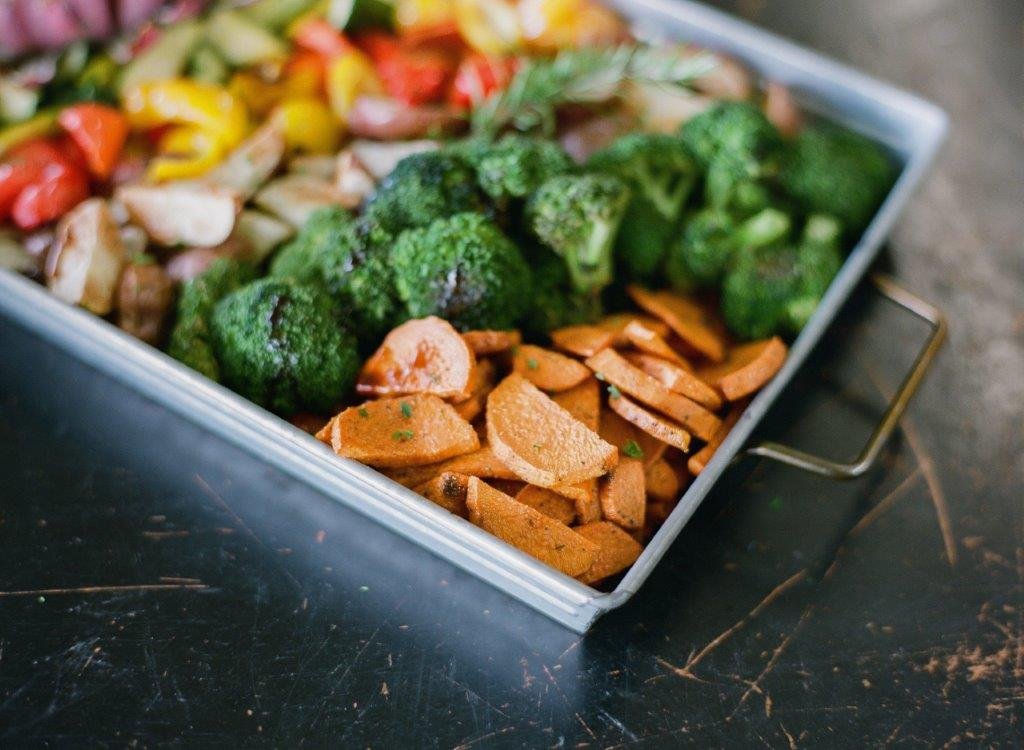 metal tray with roasted carrots, broccoli, mushrooms, and bell peppers