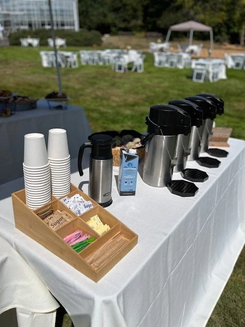 Coffee station with black coffee dispensers, coffee cups, etc.
