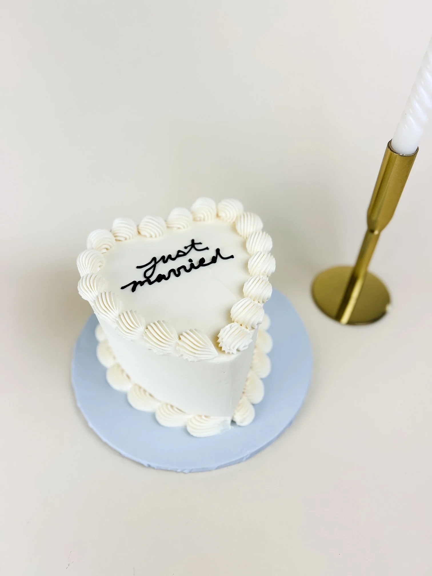 heart cake with "just married" piped on top with candle
