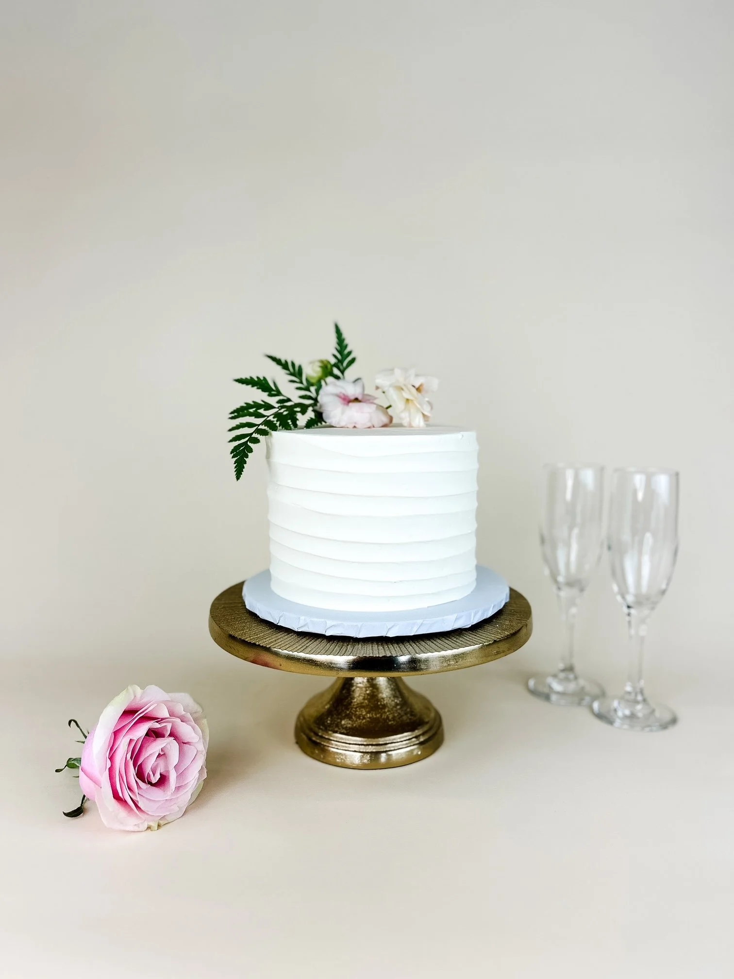 white cake with line texture with champagne glasses