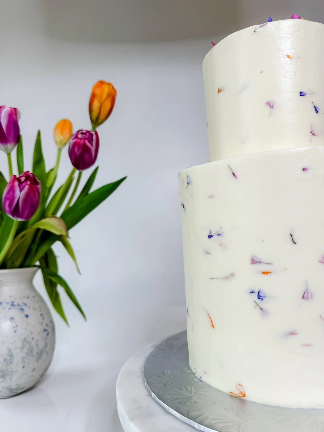 edible flower confetti cake, two tiers with barrel cake tier on bottom