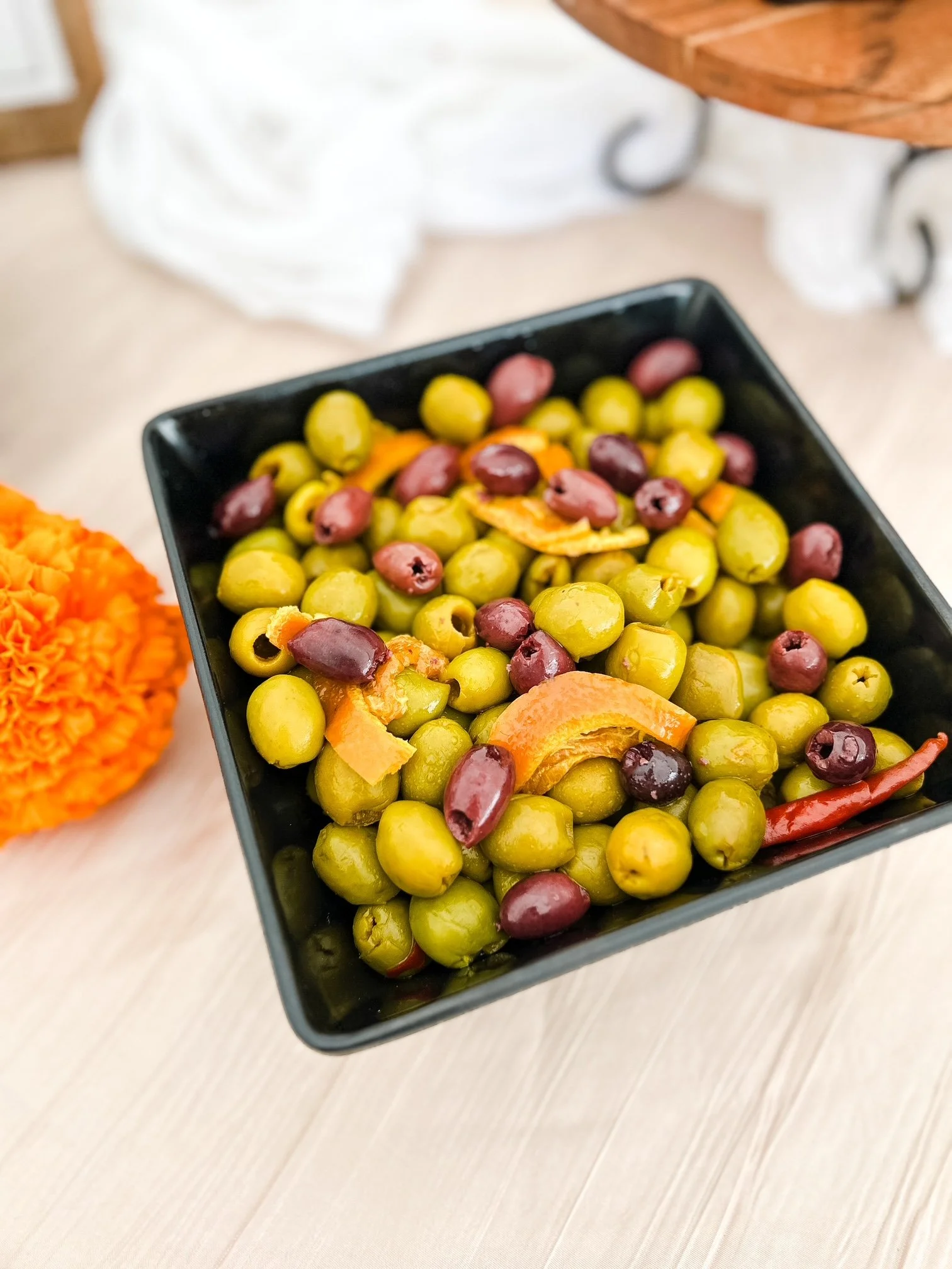 A bowl filled with assorted marinated green olives