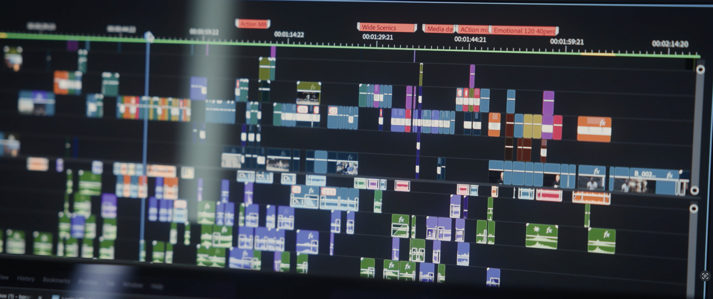 A computer screen displaying a colorful video editing timeline with multiple tracks of video and audio clips.