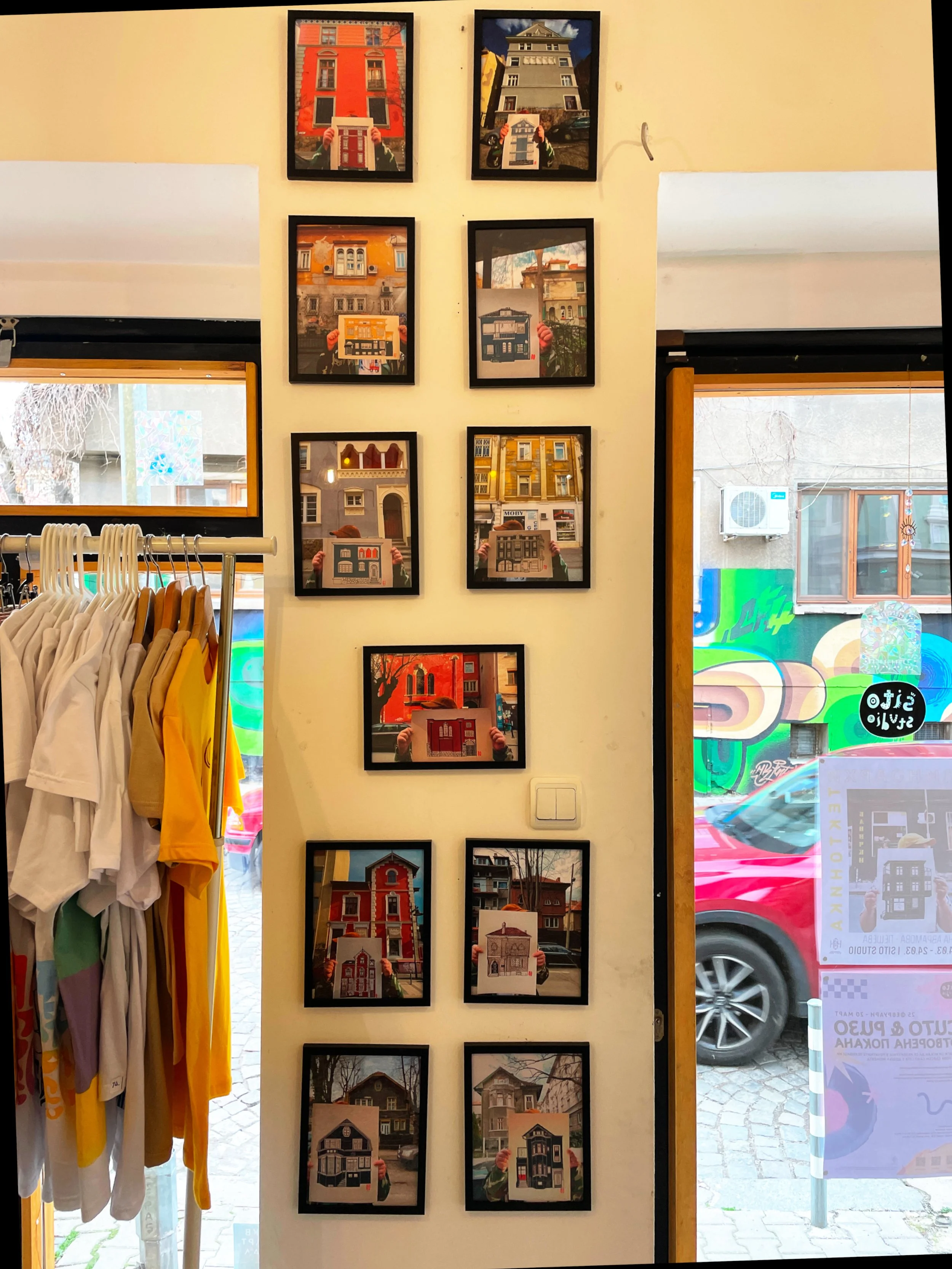 Wall with photos of the prints in front of the original buildings