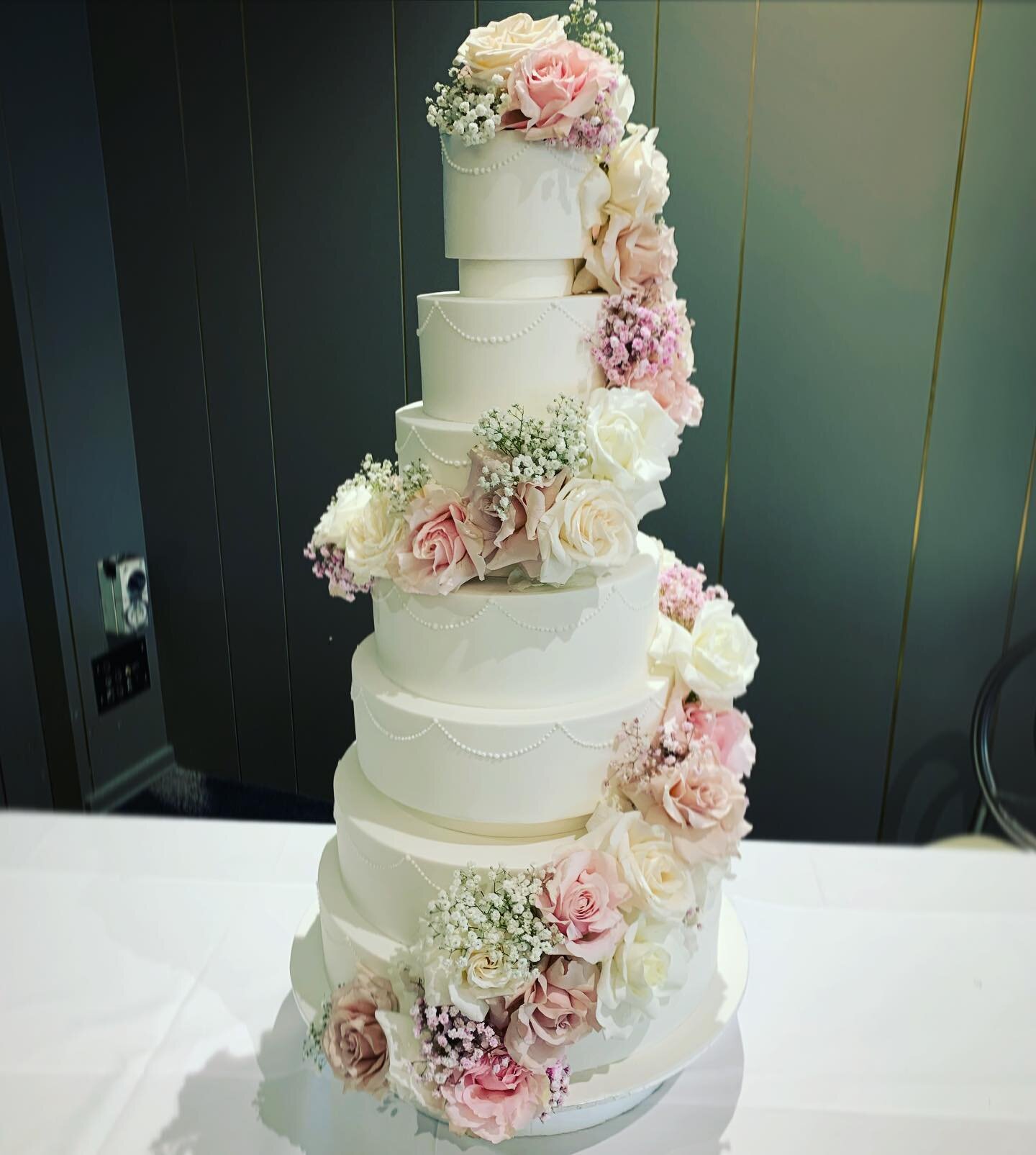 Spring vibes with fresh flowers wrapping around this elegant hand piped cake