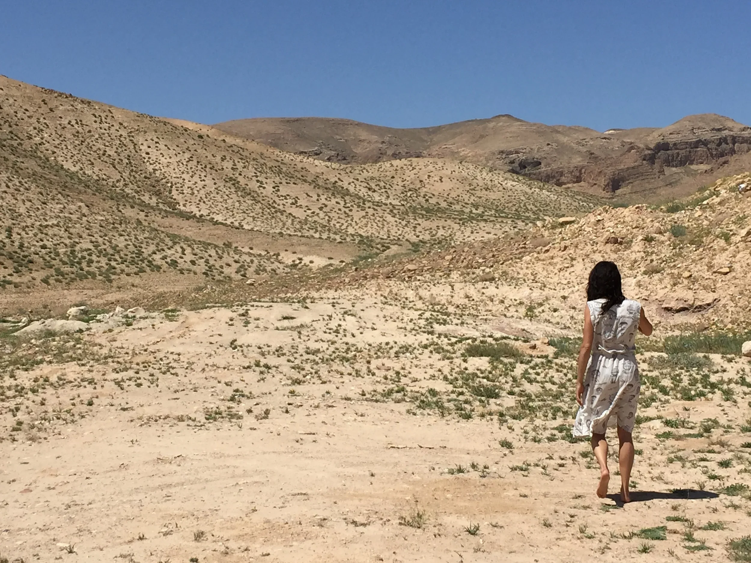 Woman walking barefoot through the desert on a holistic healing journey