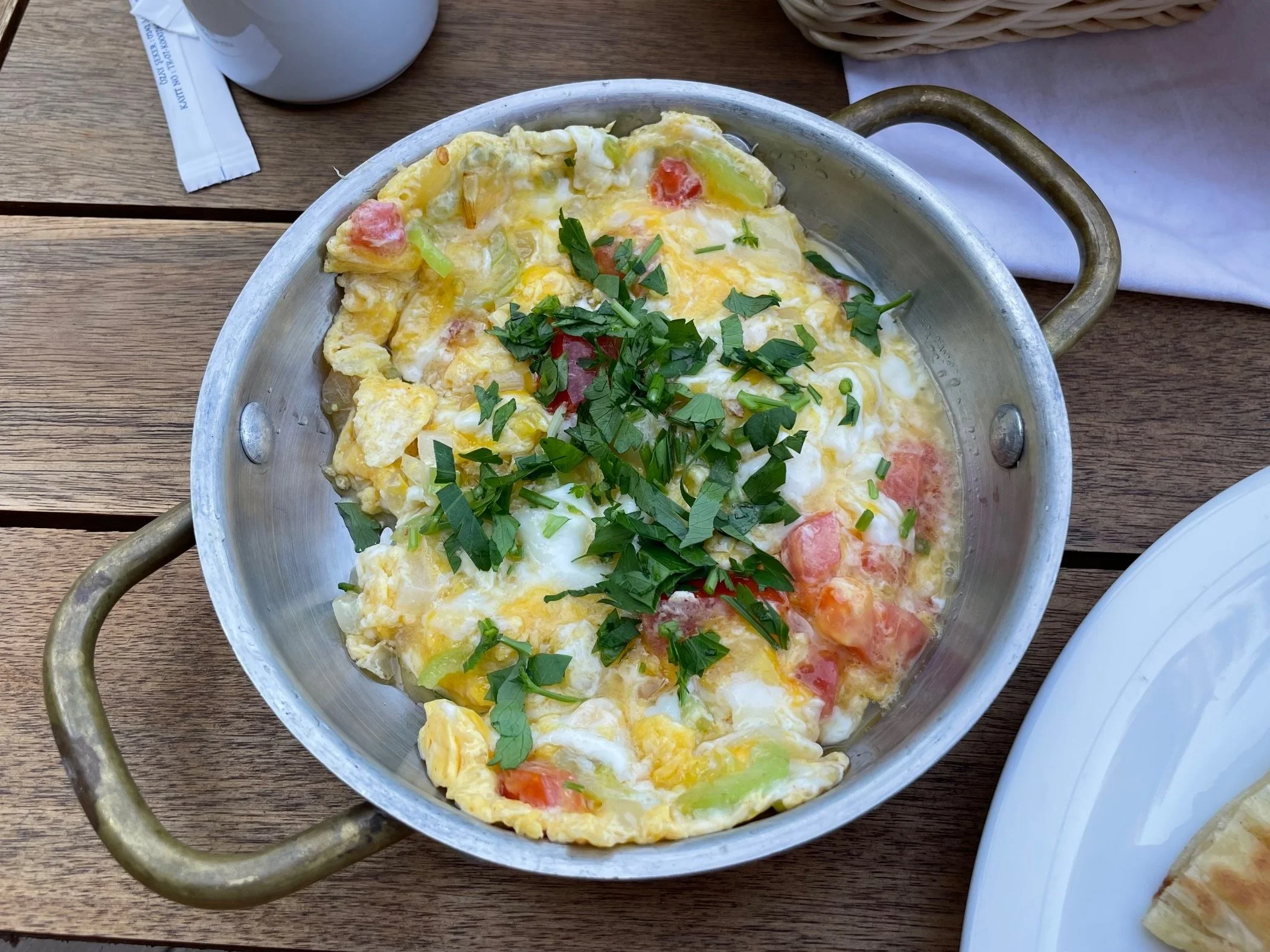Photo of a metal dish containing scrambled eggs topped with parsley