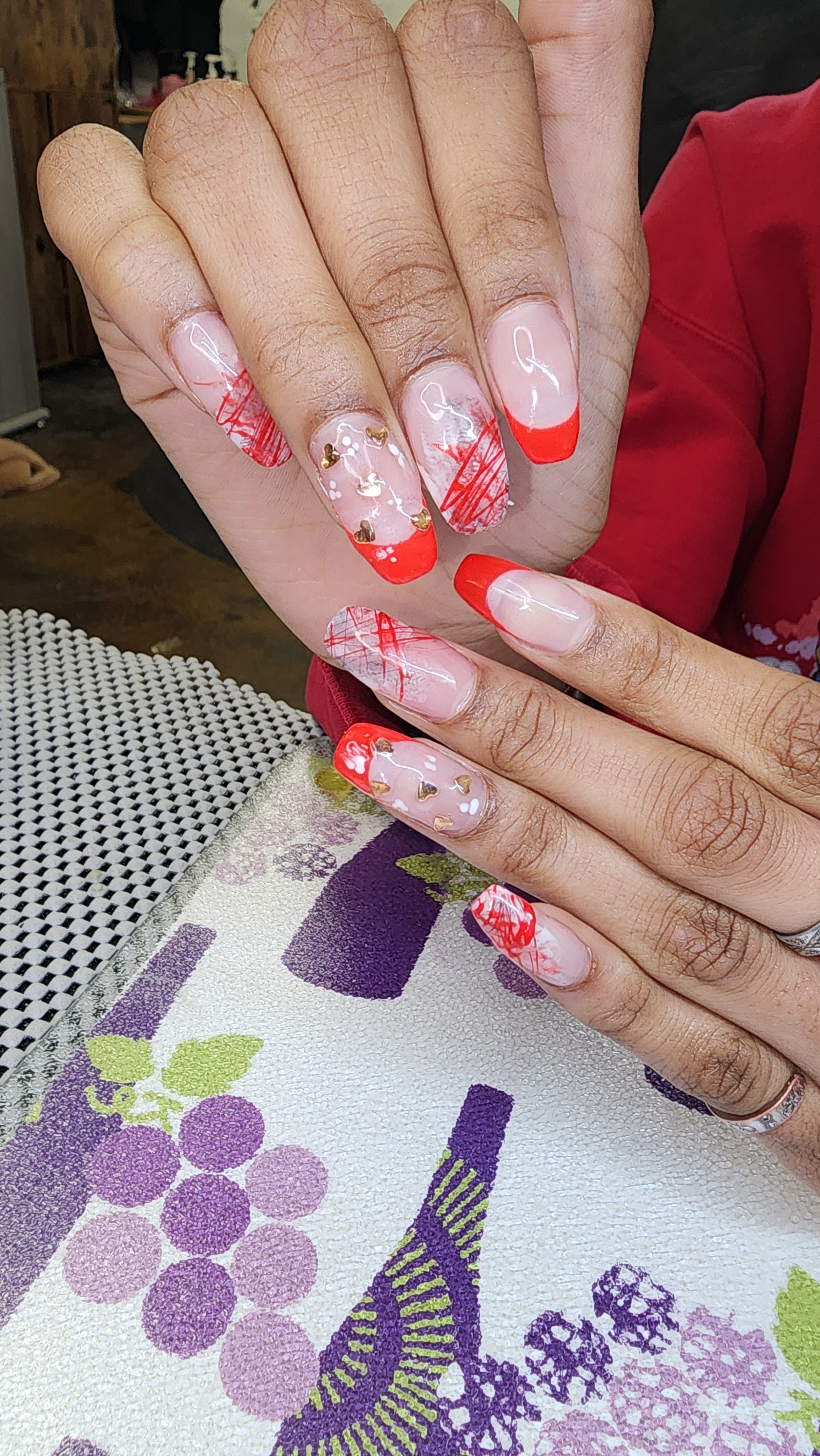 Rounded square nails with hearts and red fee-hand nail art
