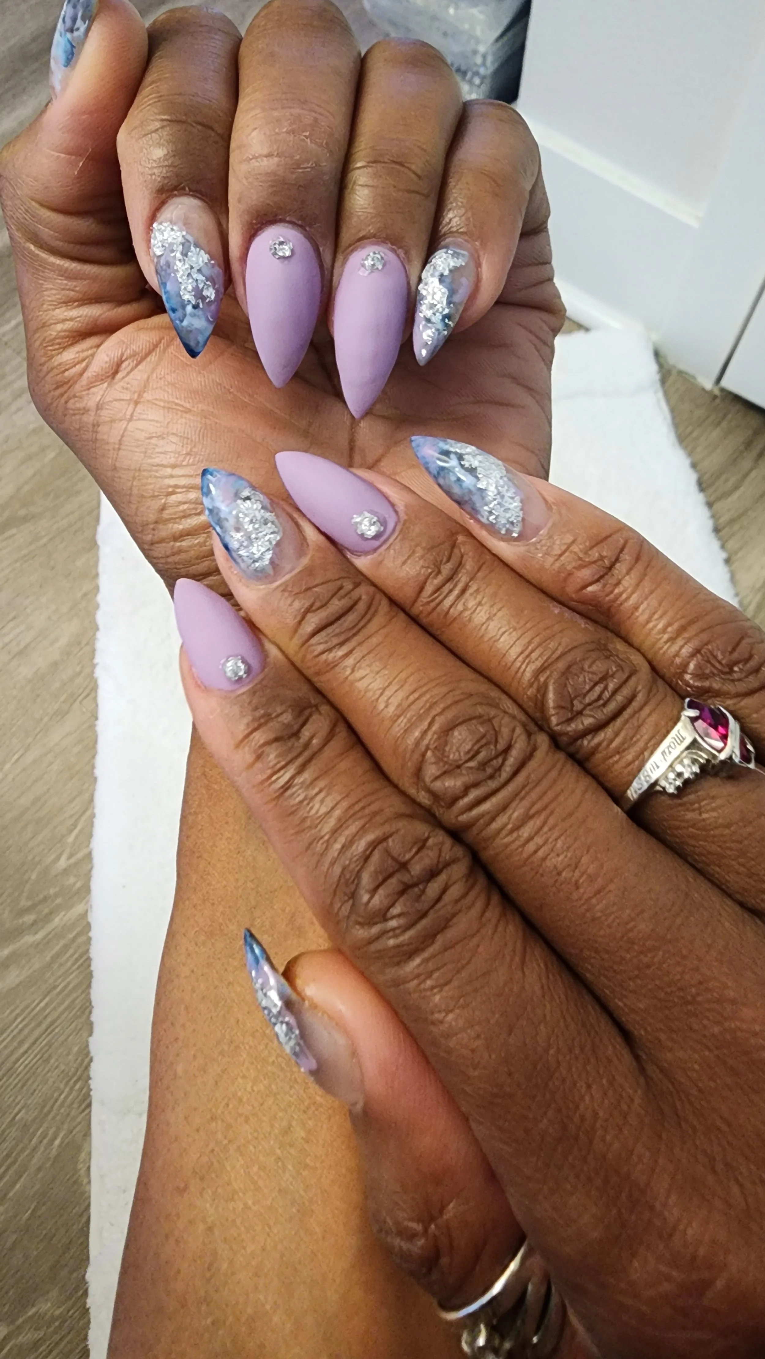 light purple stiletto nails with nail art and gems