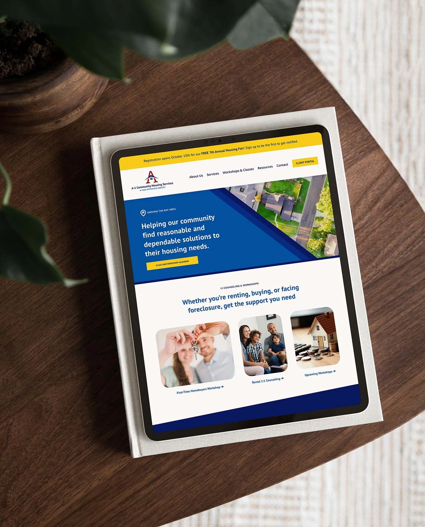 squarespace website for bay area nonprofit with housing support services on tablet on wooden table with potted plant