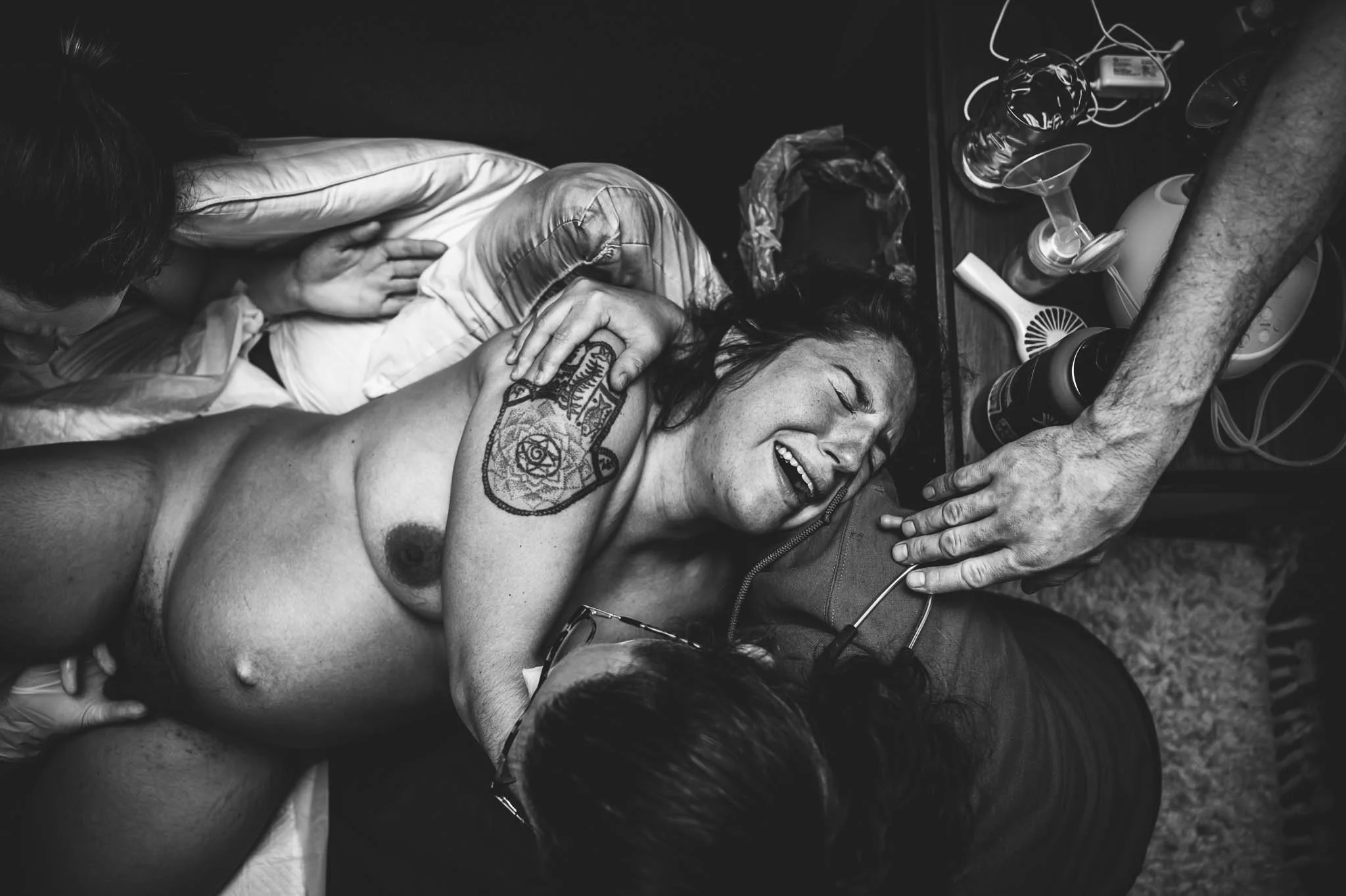 home-brith-midwife-helps-push-cervical-lip-out-of-the-way-during-contraction-mom-leans-into-other-midwife-doula-and-husband-support-sarah-elizabeth-birth-photography-7173.jpg