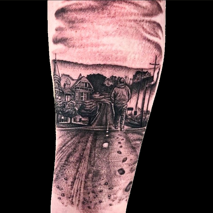 Landscape tattoo with a pink sky and dark tree silhouettes.