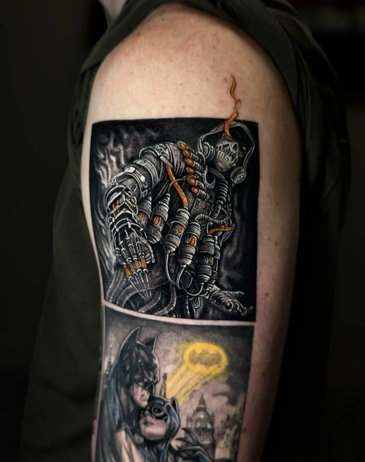 Black and grey science-fiction character tattoo with orange accents above Batman and Catwoman, by Chris Kennedy.