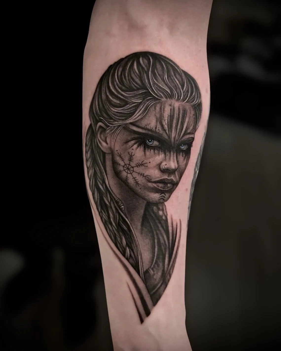 Black and grey Viking woman portrait tattoo with blue eyes, by Chris Kennedy.