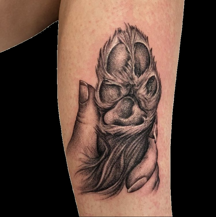 Black and grey skull tattoo with an ornate pointed headdress.
