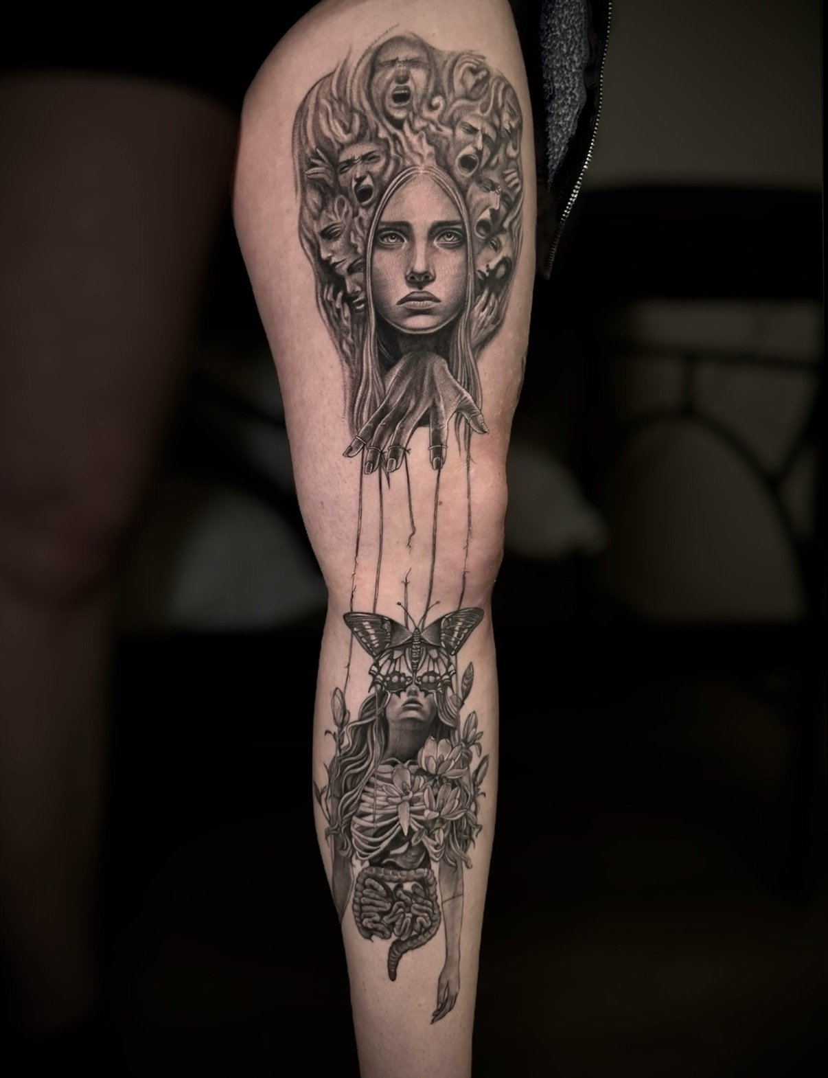 Black and grey surreal portrait sleeve with marionette strings, butterfly, flowers and anatomy, by Chris Kennedy.