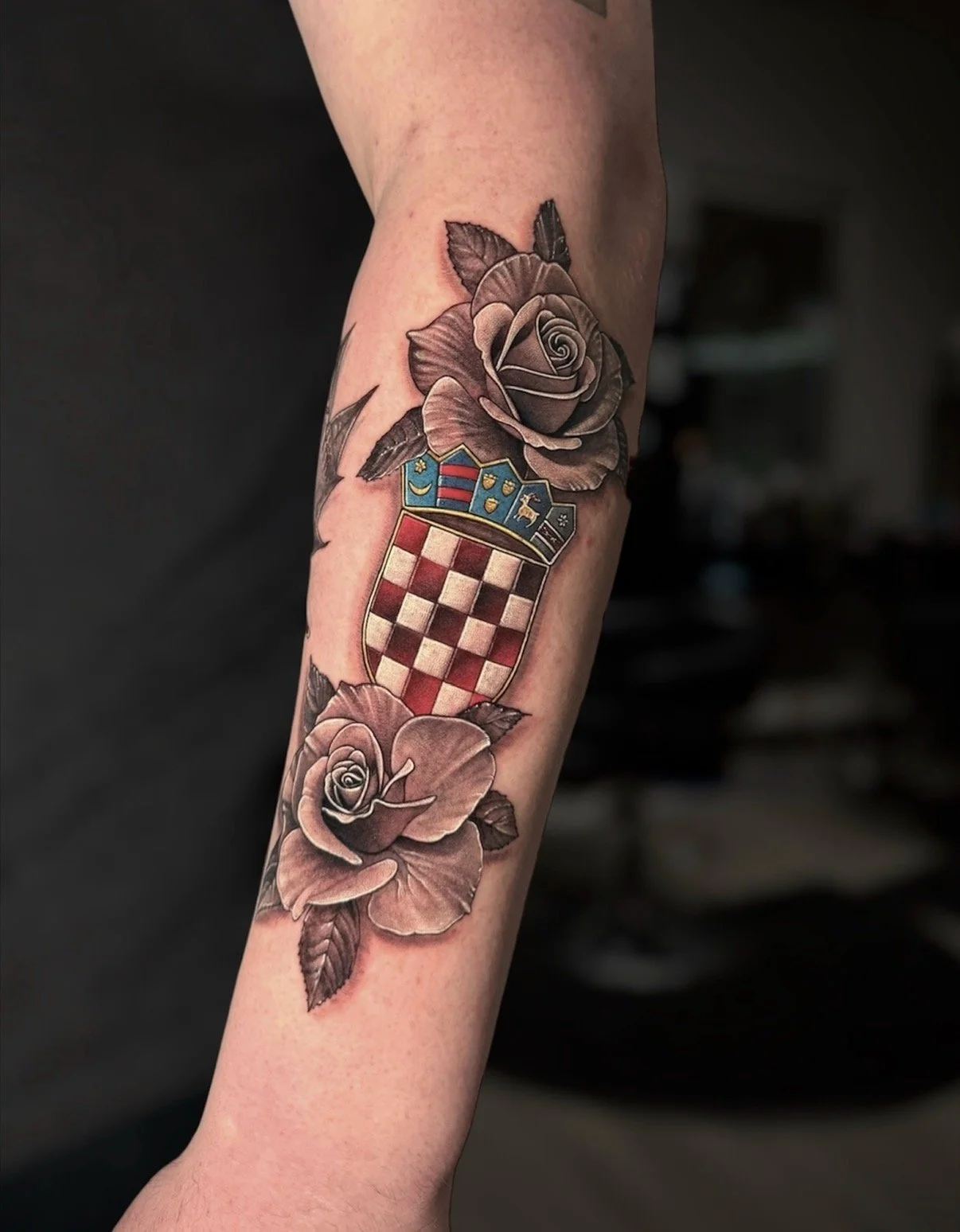 Colour Croatian coat of arms tattoo framed by black and grey roses, by Chris Kennedy.