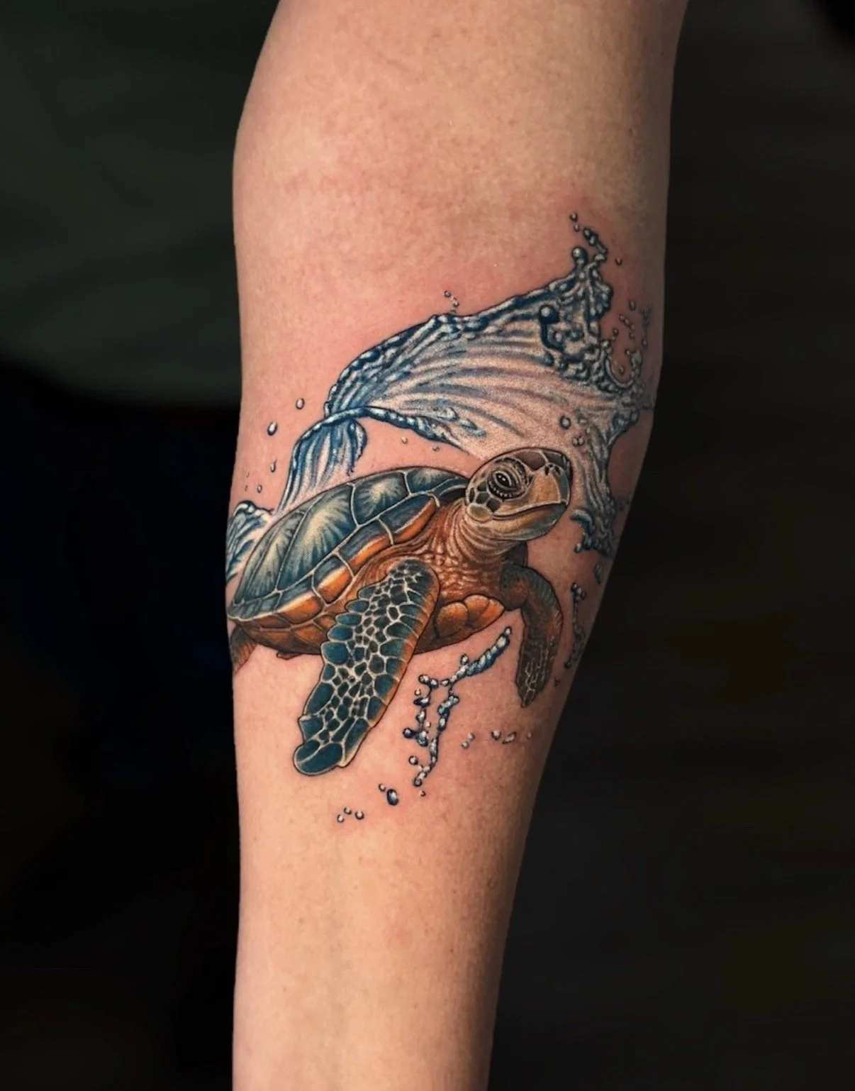 Colour sea turtle tattoo with a flowing wave, by Chris Kennedy.