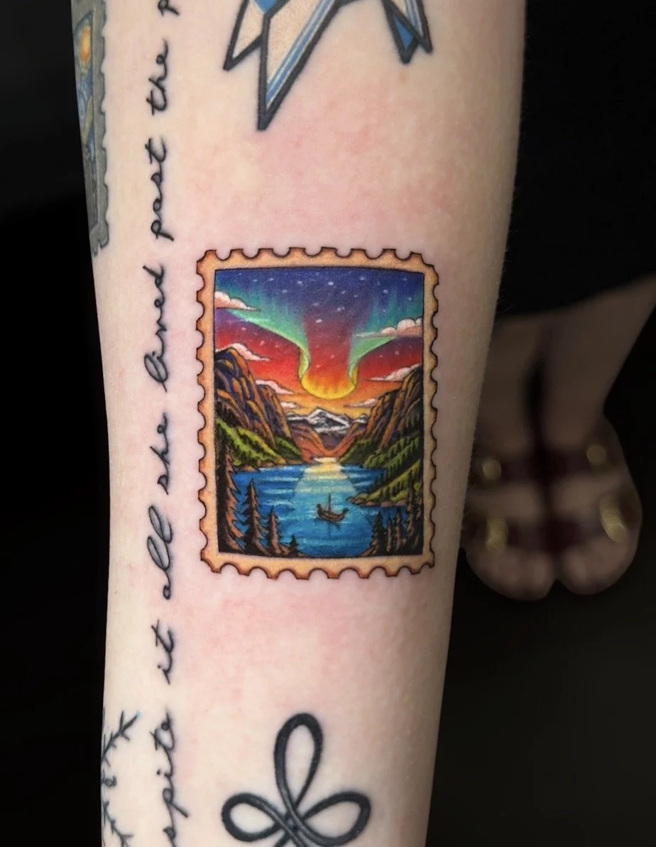 Colour postage stamp tattoo of northern lights above a mountain fjord with a small boat and pine trees, by Chris Kennedy.