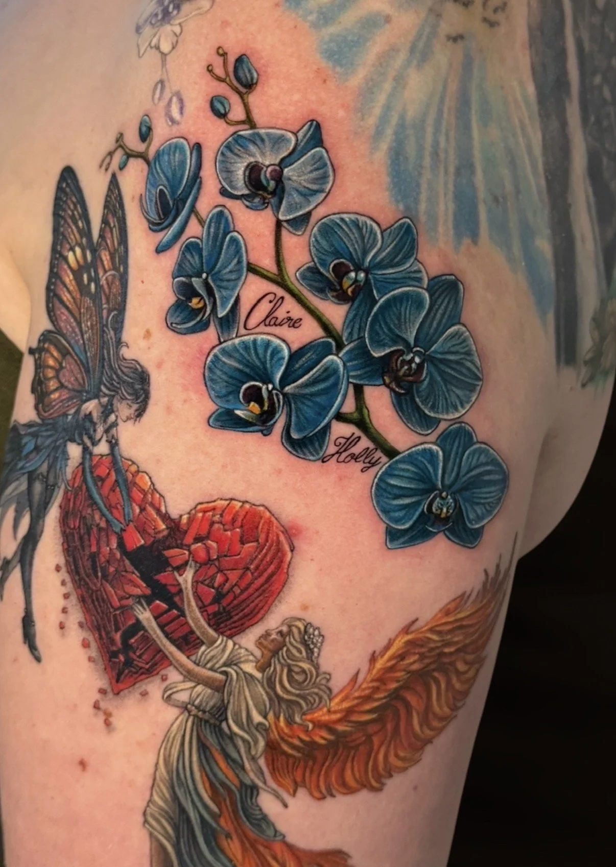Blue orchid flower tattoo with lettering, by Chris Kennedy.
