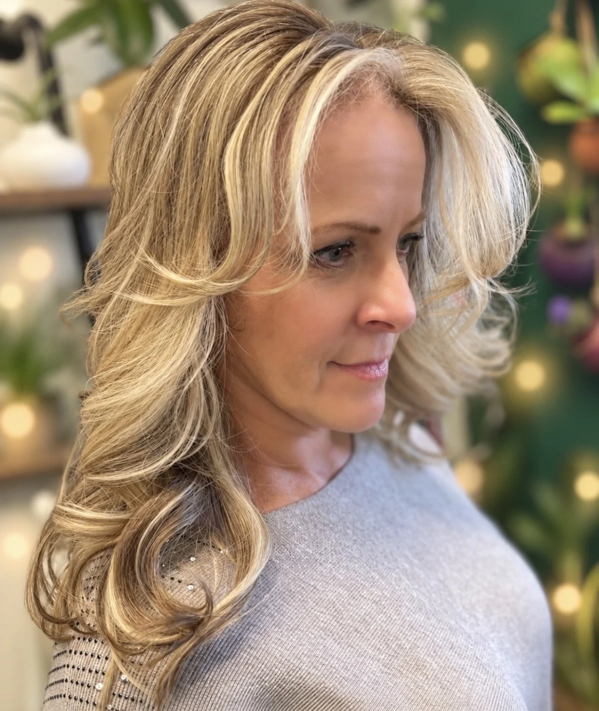 Gray blending with dimensional blonde highlights and soft layered curls at Zen Den Salon & Boutique in Encinitas, CA.