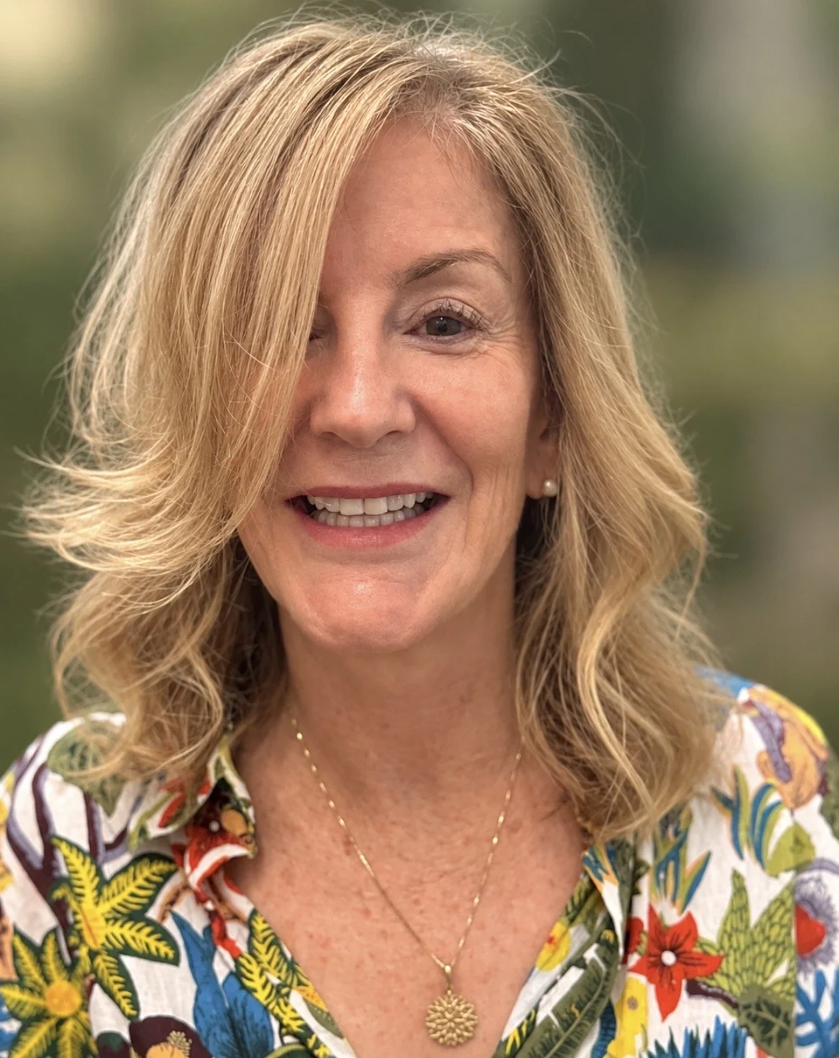 Woman with naturally blonde hair enhanced by subtle highlights and lowlights, showcasing soft dimension and graceful aging.
