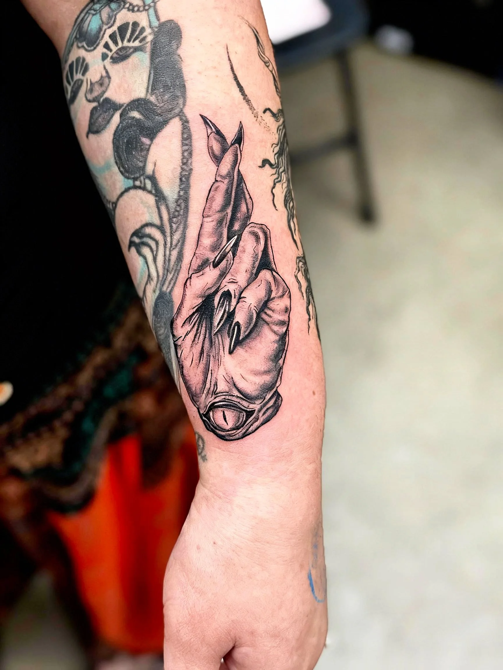 Black and grey illustrative hand tattoo by Dark Mark Ink Tattoo Studio
