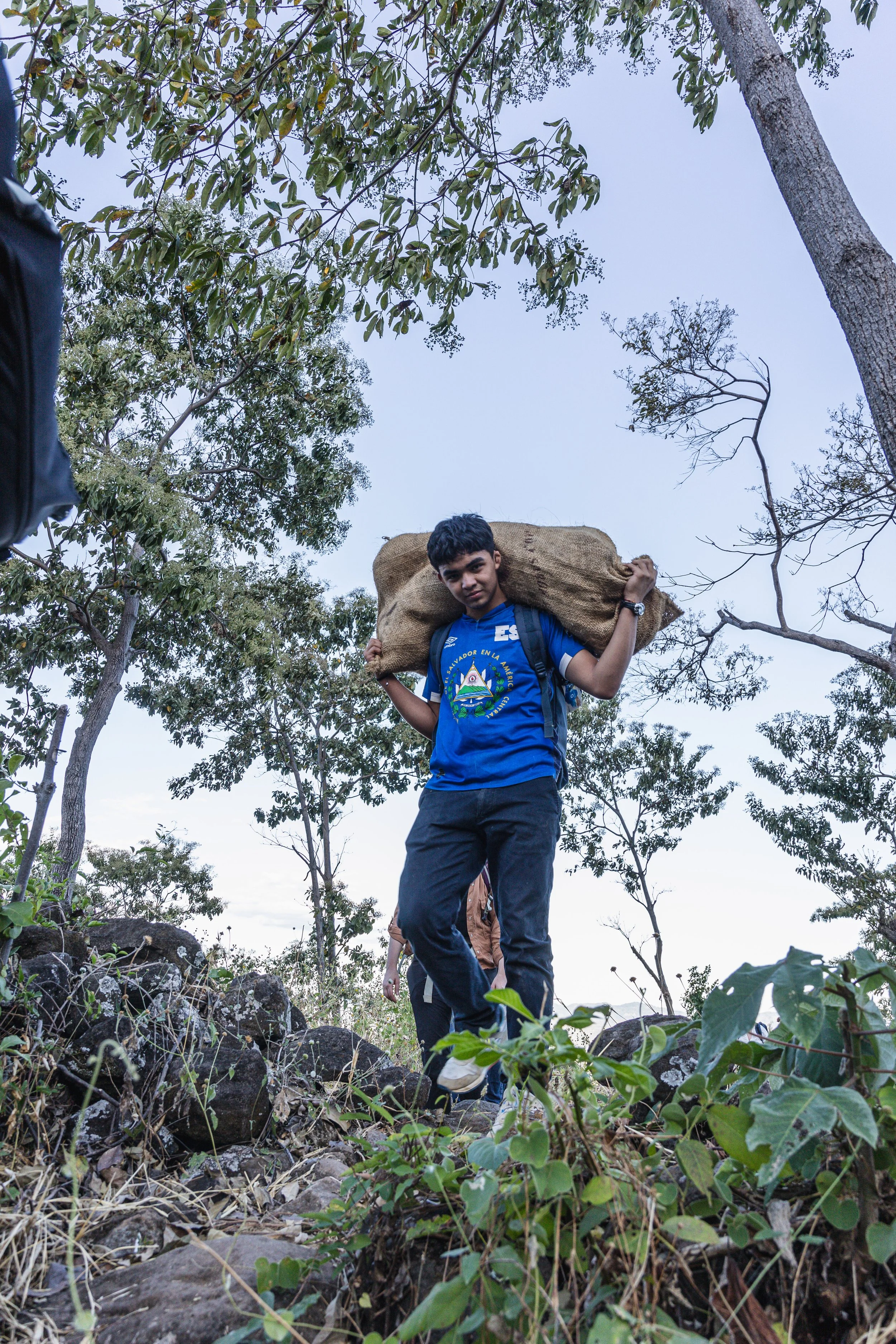 boy carrying sack of cacao pods in el salvador