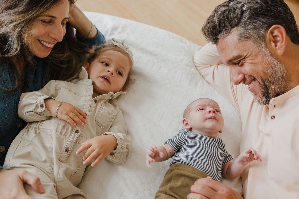 Lifestyle family portraits at home with toddler and newborn